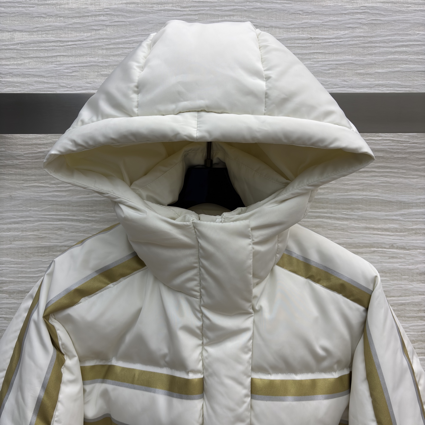 D家 撞色连帽羽绒服 是冬日里的温柔铠甲 米白底色衬出干净氛围 金调条纹与侧边装饰点亮细节 连帽设计裹紧