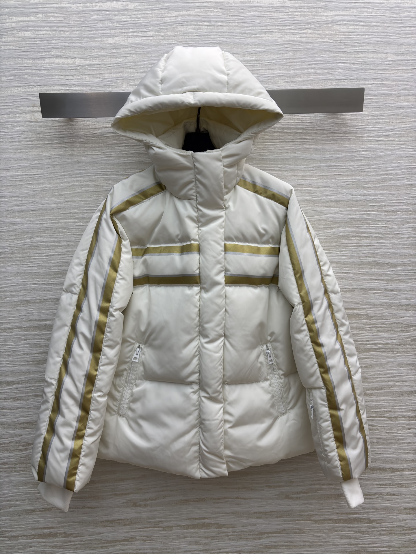D家 撞色连帽羽绒服 是冬日里的温柔铠甲 米白底色衬出干净氛围 金调条纹与侧边装饰点亮细节 连帽设计裹紧