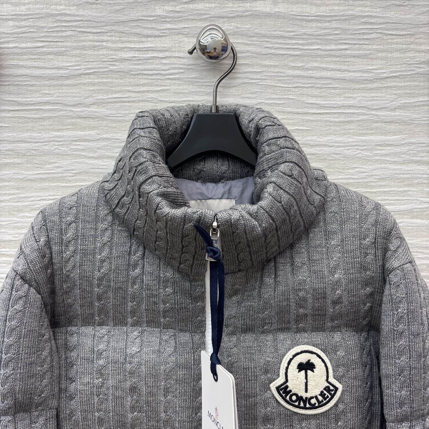 Mo家 立领拉链羽绒服 绞花与蓬松的温柔碰撞 绞花纹理裹满软绒暖意 标志性徽章缀出精致辨识度 立领饱满充