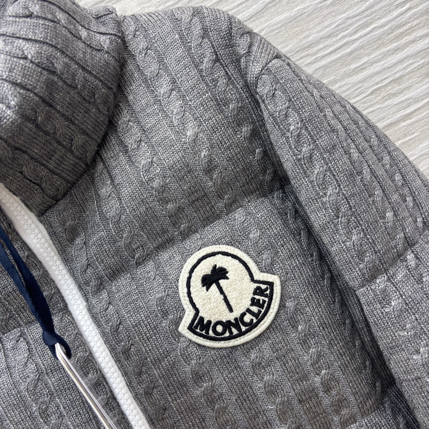 Mo家 立领拉链羽绒服 绞花与蓬松的温柔碰撞 绞花纹理裹满软绒暖意 标志性徽章缀出精致辨识度 立领饱满充