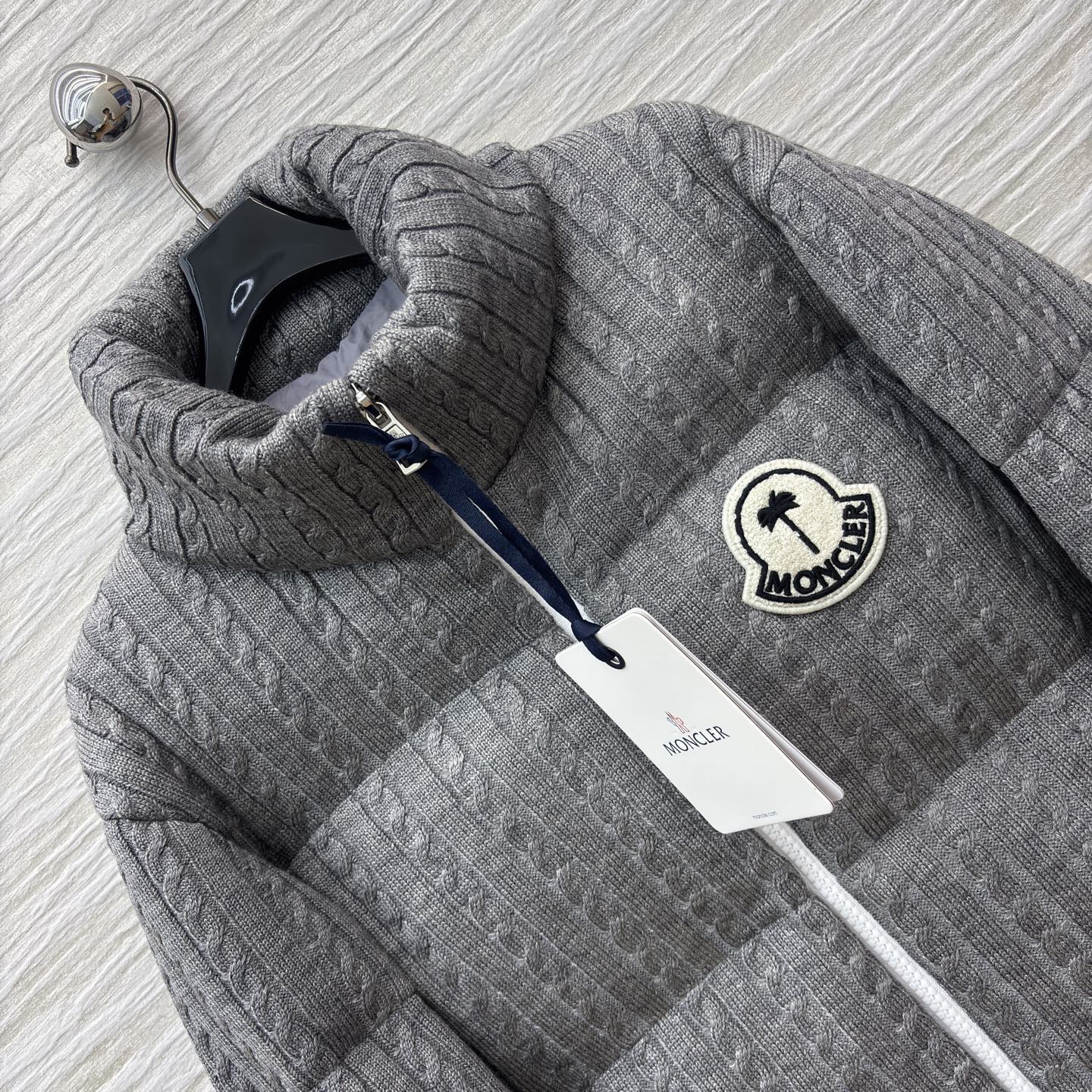 Mo家 立领拉链羽绒服 绞花与蓬松的温柔碰撞 绞花纹理裹满软绒暖意 标志性徽章缀出精致辨识度 立领饱满充