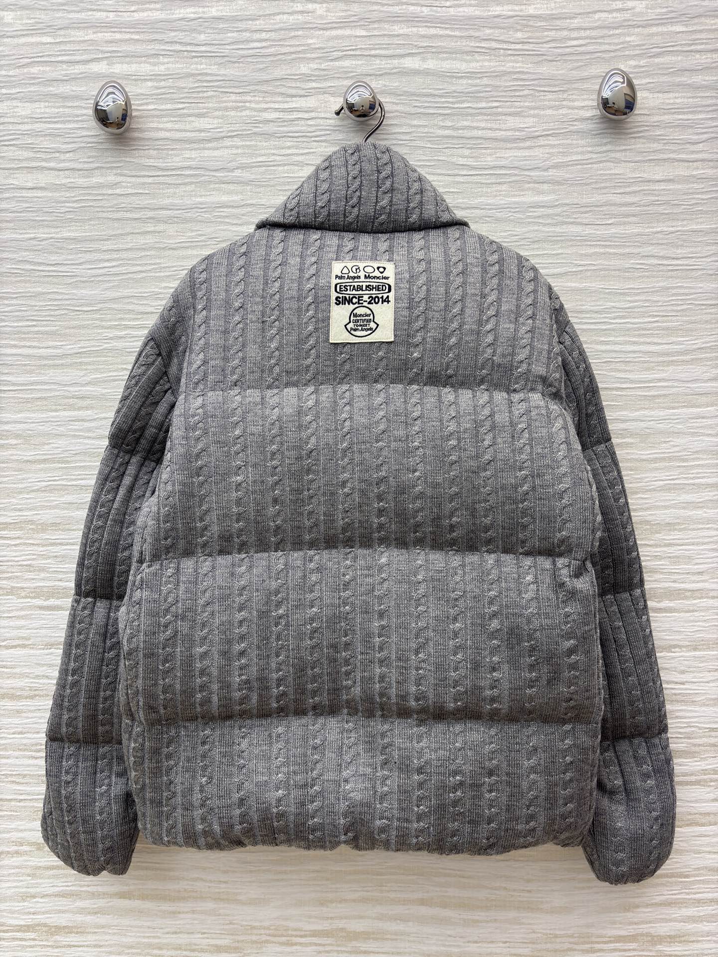 Mo家 立领拉链羽绒服 绞花与蓬松的温柔碰撞 绞花纹理裹满软绒暖意 标志性徽章缀出精致辨识度 立领饱满充