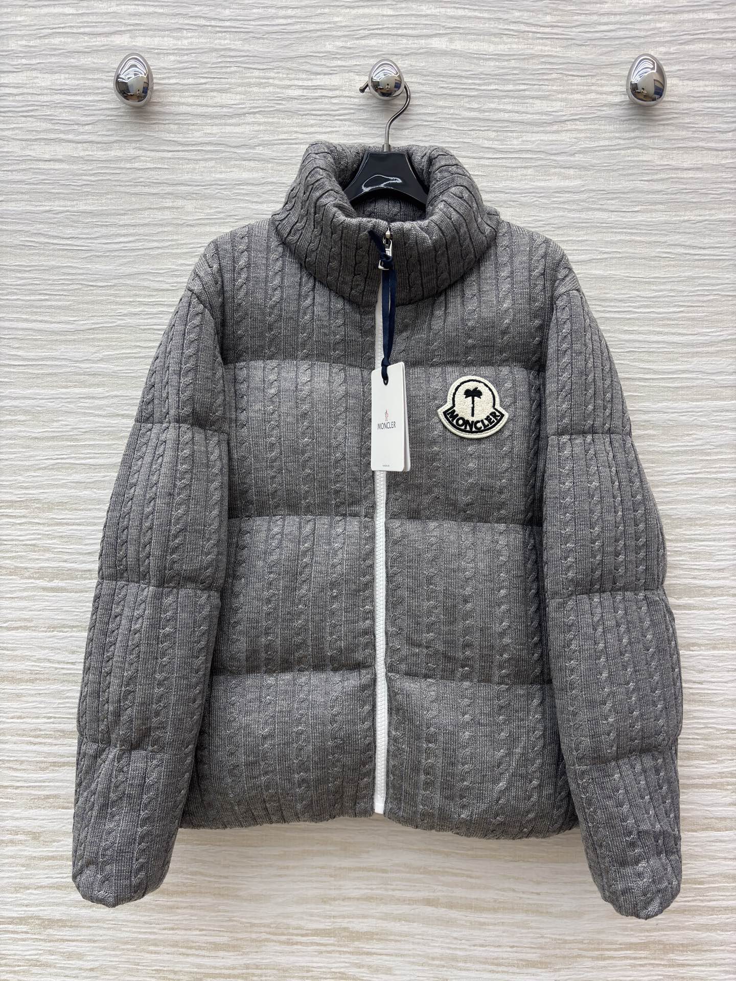 Mo家 立领拉链羽绒服 绞花与蓬松的温柔碰撞 绞花纹理裹满软绒暖意 标志性徽章缀出精致辨识度 立领饱满充