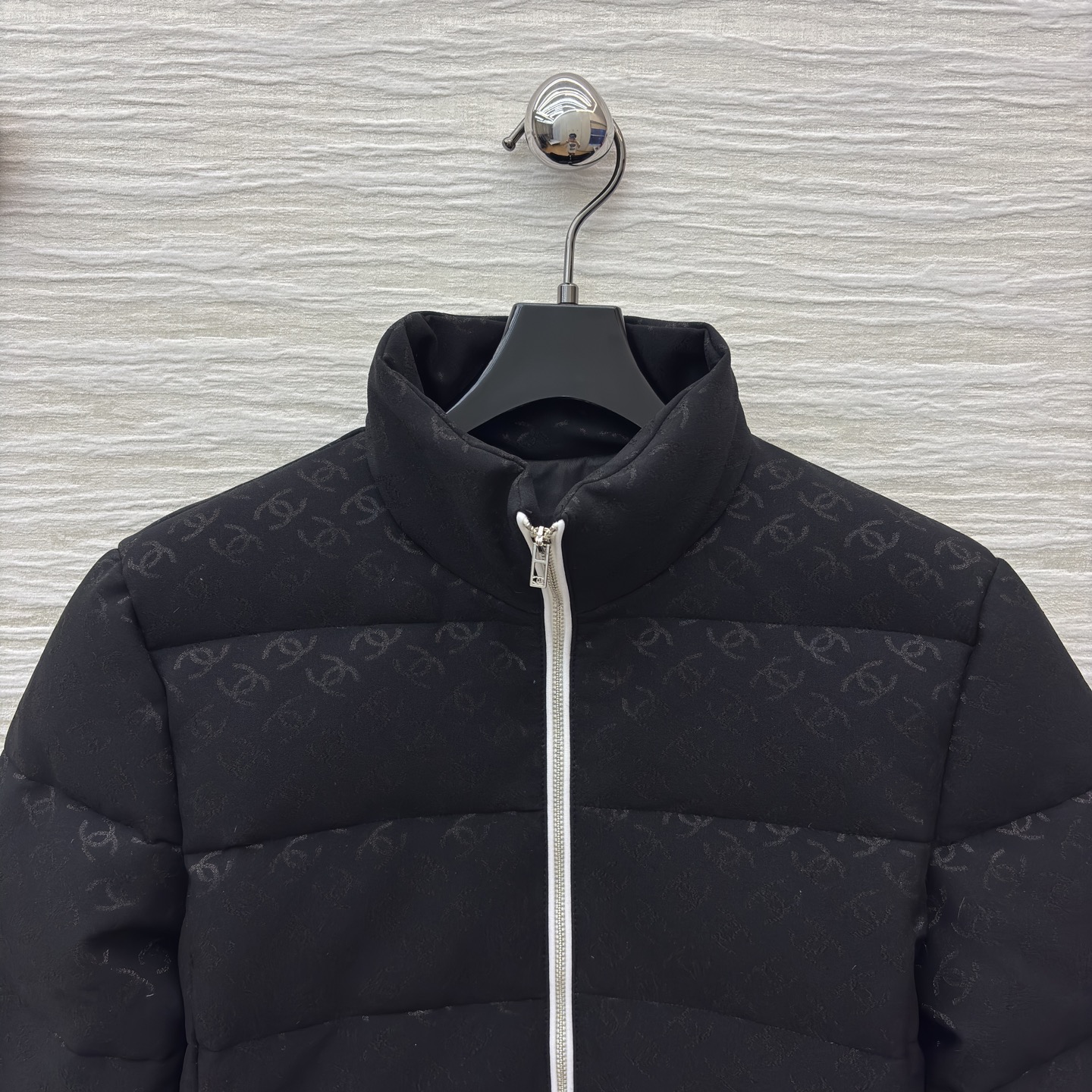 香家黑色立领羽绒服 满印暗纹双C低调衬质感 横向绗缝搭配银白拉链撞色 利落短款版型适配各种内搭 日常出街