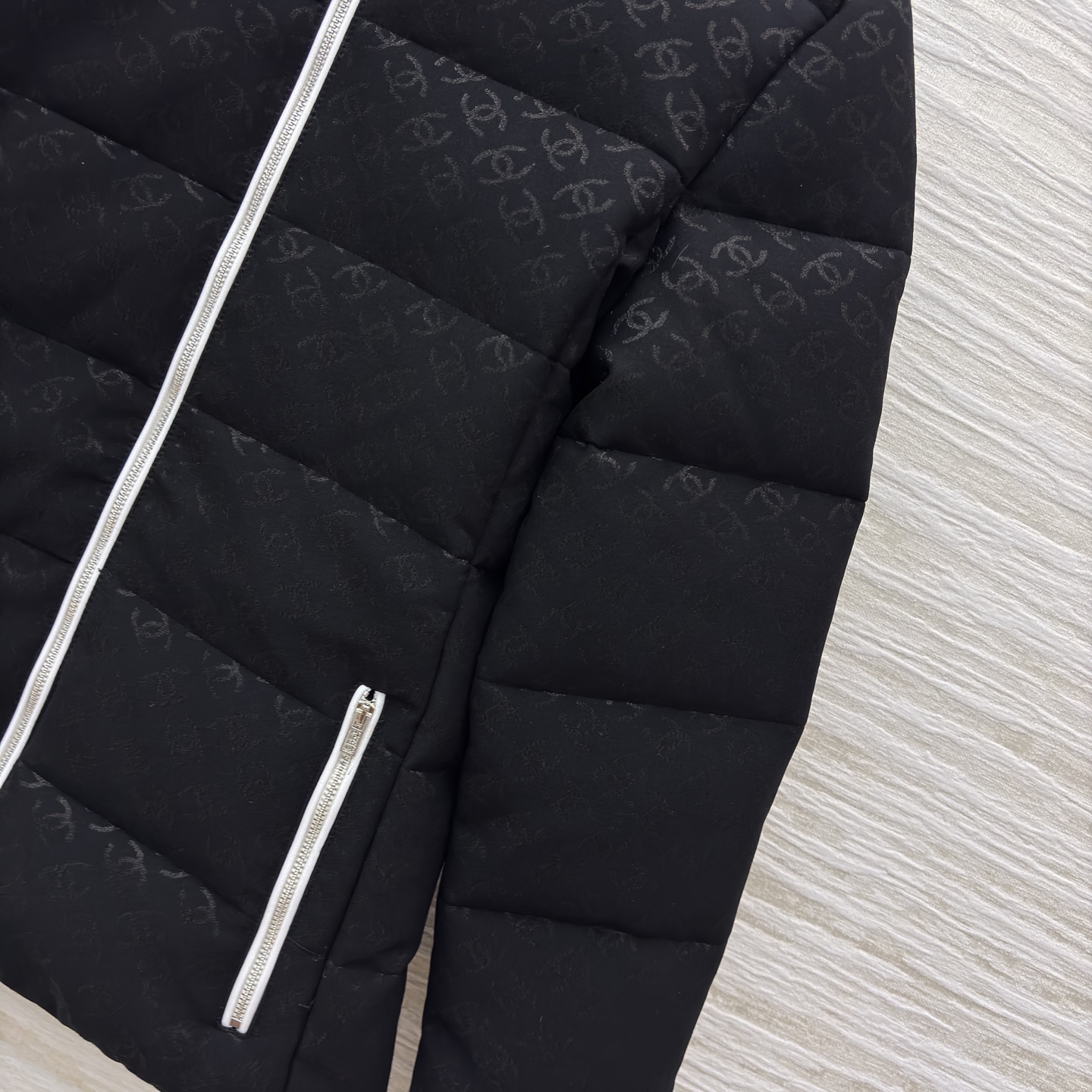 香家黑色立领羽绒服 满印暗纹双C低调衬质感 横向绗缝搭配银白拉链撞色 利落短款版型适配各种内搭 日常出街