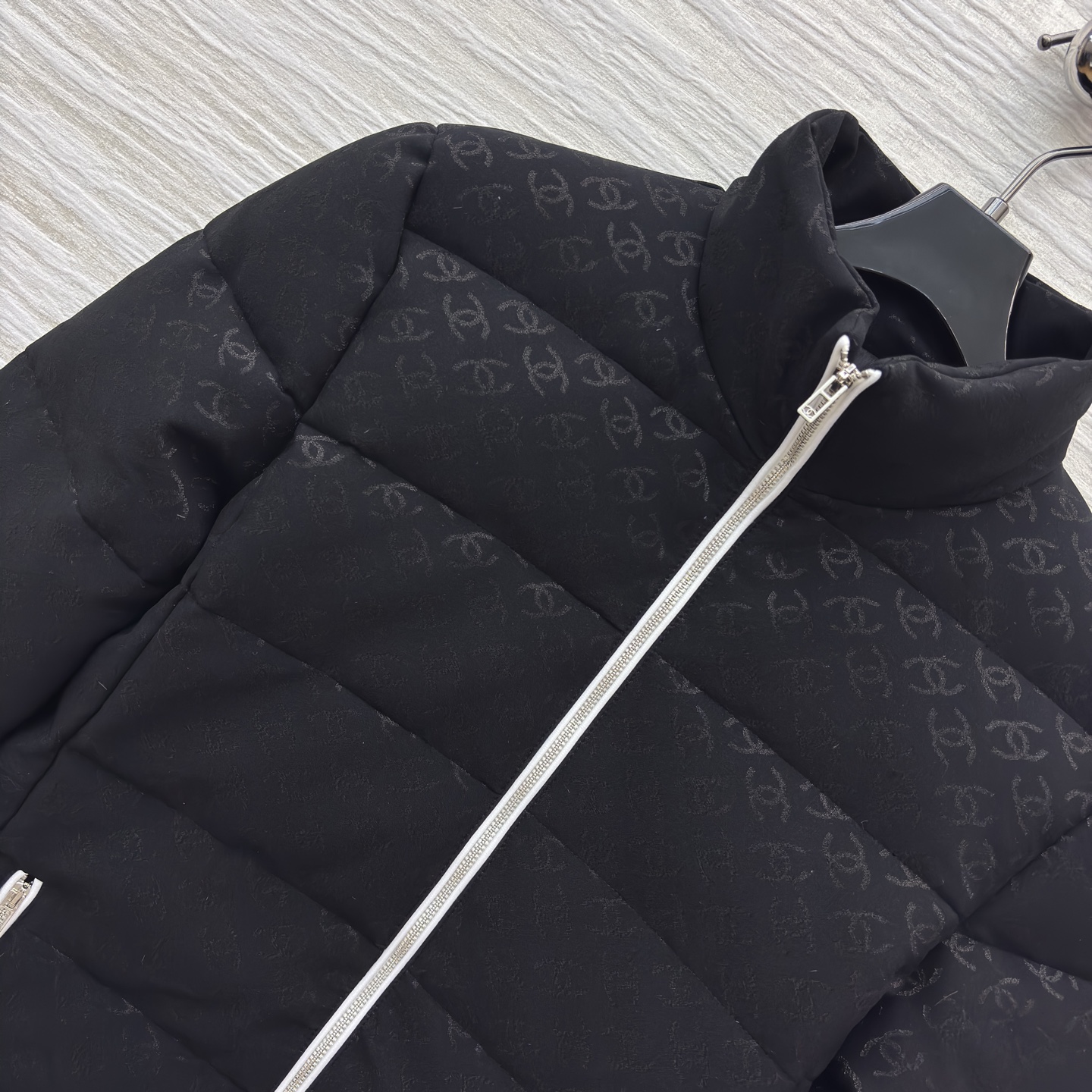 香家黑色立领羽绒服 满印暗纹双C低调衬质感 横向绗缝搭配银白拉链撞色 利落短款版型适配各种内搭 日常出街