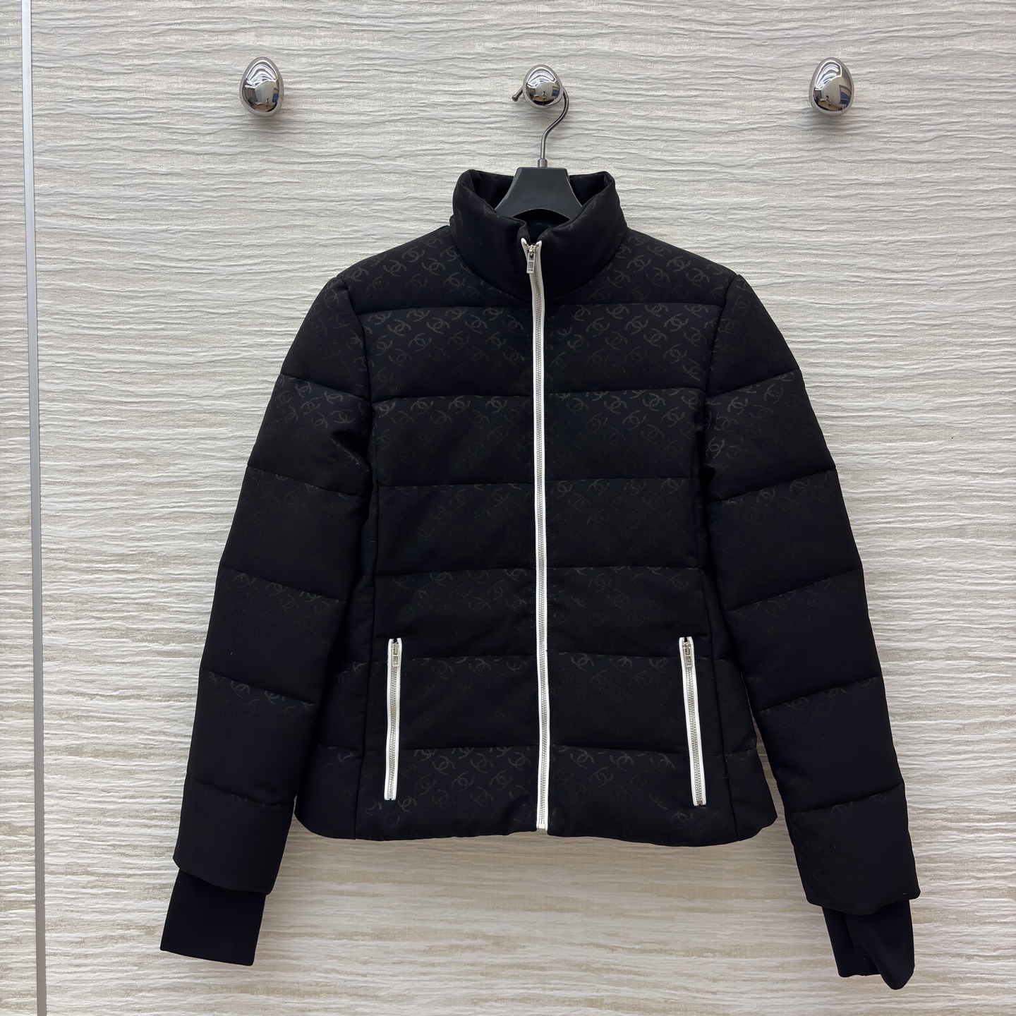 香家黑色立领羽绒服 满印暗纹双C低调衬质感 横向绗缝搭配银白拉链撞色 利落短款版型适配各种内搭 日常出街