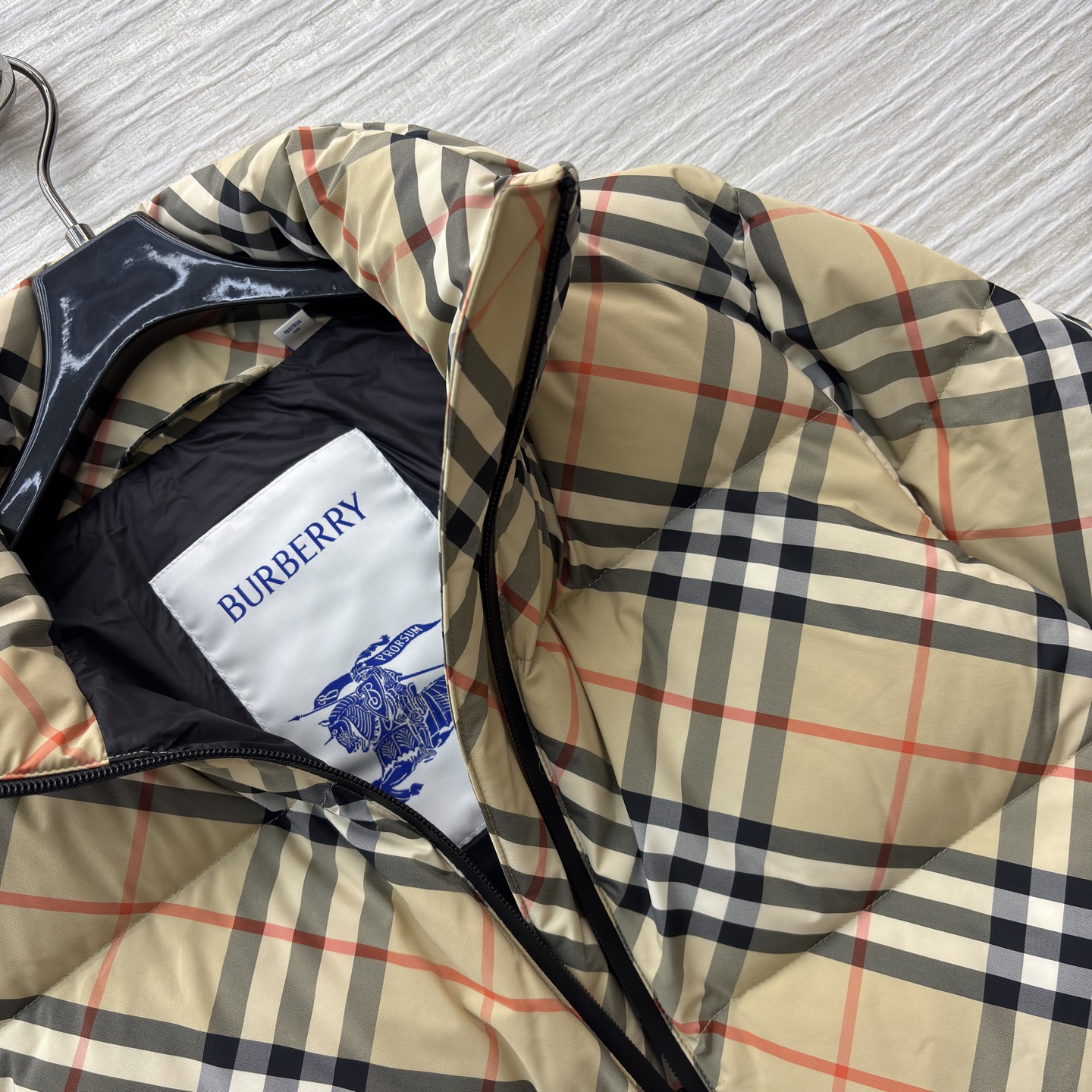 B经典格纹羽绒服 棕黄底色交织黑白红线条 自带复古腔调 立领短款廓形 松弛又利落 拉链处的细节藏着精致感