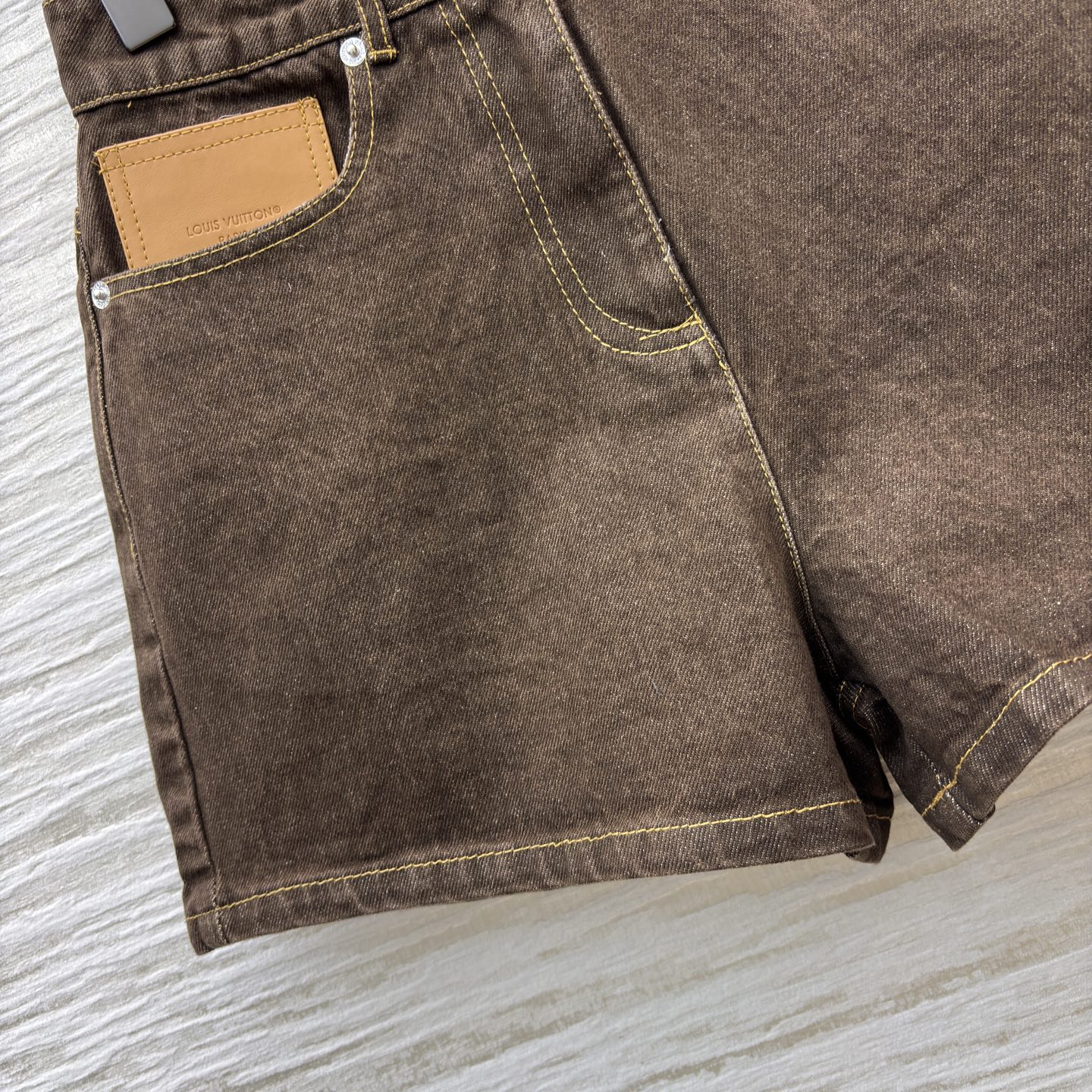 L家 深棕牛仔短裤 自带复古质感 明黄色缝线勾出利落轮廓 口袋处的皮质贴片是点睛小心思 版型利落不拖沓 