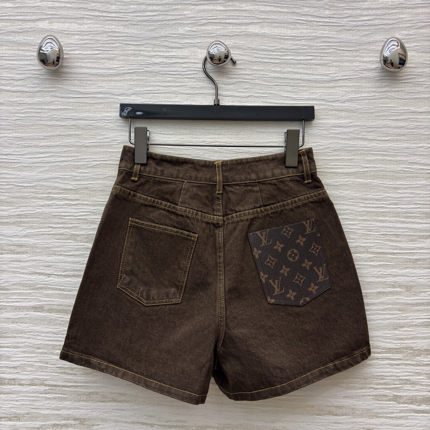 L家 深棕牛仔短裤 自带复古质感 明黄色缝线勾出利落轮廓 口袋处的皮质贴片是点睛小心思 版型利落不拖沓 