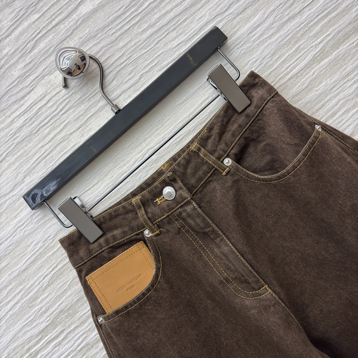 L家深棕调牛仔长裤 自带复古质感 明黄缝线勾出利落线条 口袋皮质贴片是细节巧思 高腰阔腿版型藏肉又显比例