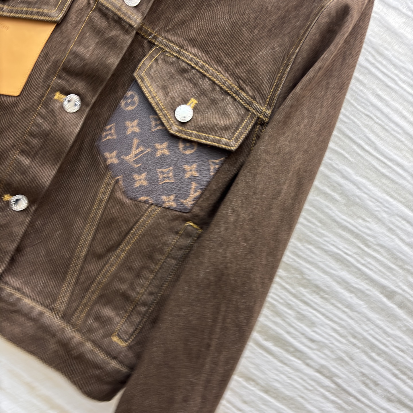 L家深棕牛仔夹克 翻领排扣设计经典耐看 自带复古质感 明黄缝线勾勒利落版型 口袋处皮质贴片是细节亮点 不