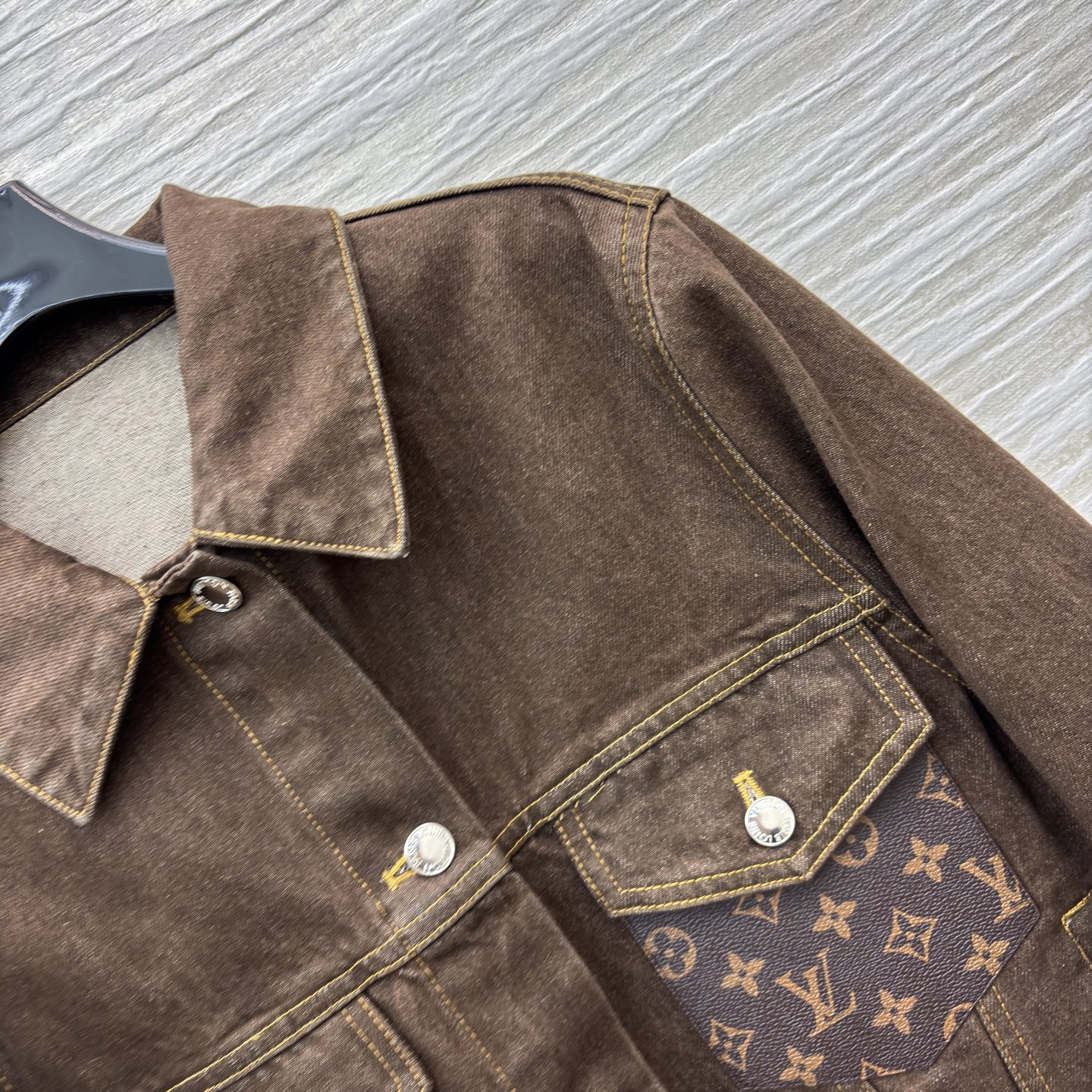 L家深棕牛仔夹克 翻领排扣设计经典耐看 自带复古质感 明黄缝线勾勒利落版型 口袋处皮质贴片是细节亮点 不