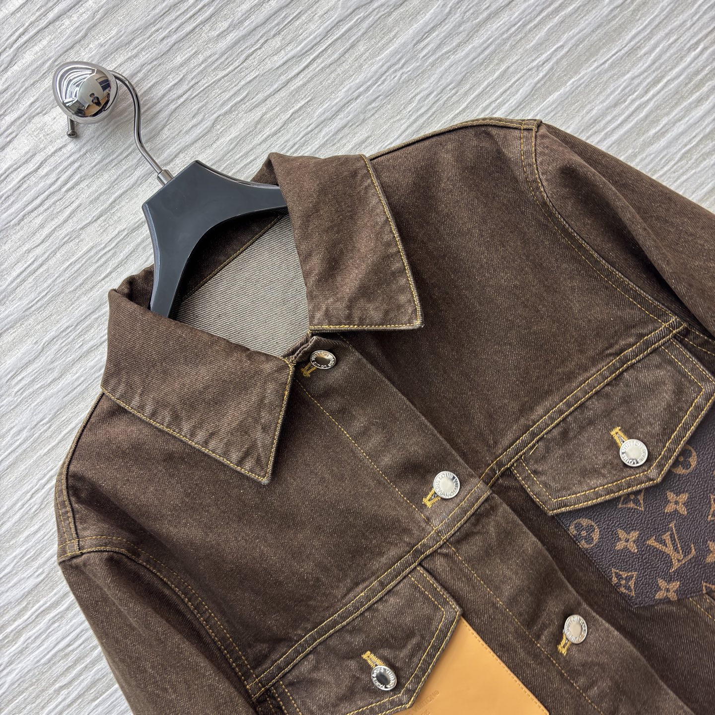 L家深棕牛仔夹克 翻领排扣设计经典耐看 自带复古质感 明黄缝线勾勒利落版型 口袋处皮质贴片是细节亮点 不