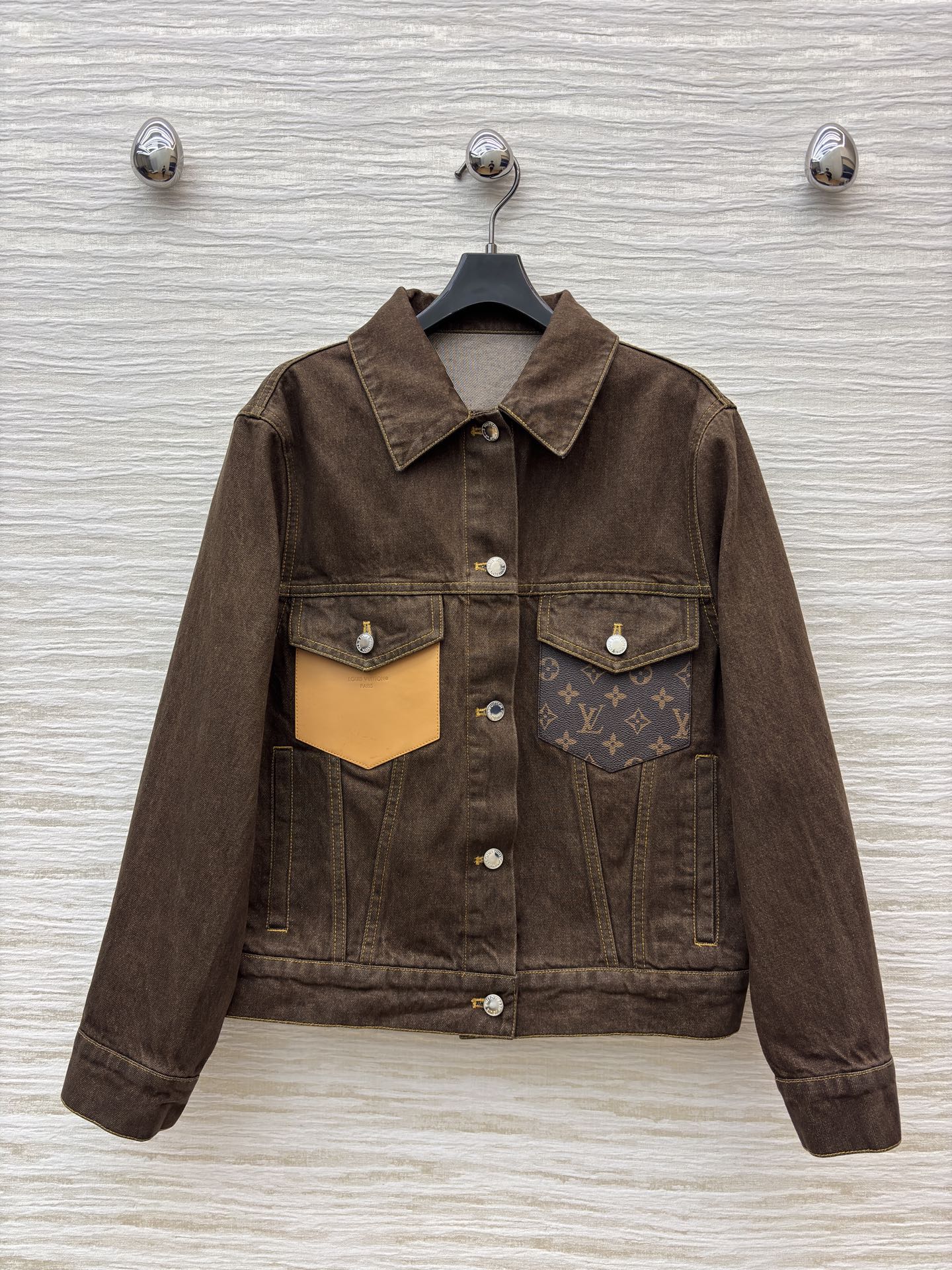 L家深棕牛仔夹克 翻领排扣设计经典耐看 自带复古质感 明黄缝线勾勒利落版型 口袋处皮质贴片是细节亮点 不