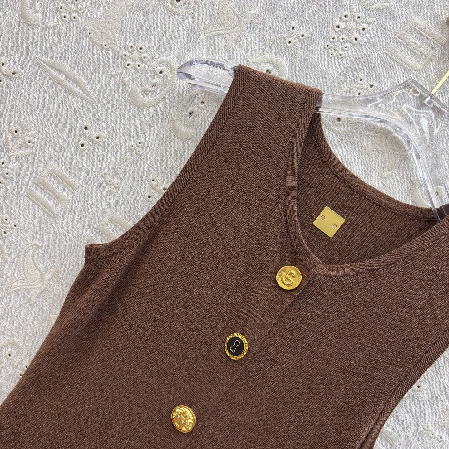 Sch 26早春 异形扣无袖针织连衣裙 以细腻坑条针织面料打造 亲肤又兼具垂坠感 经典圆领搭配纵向异形金