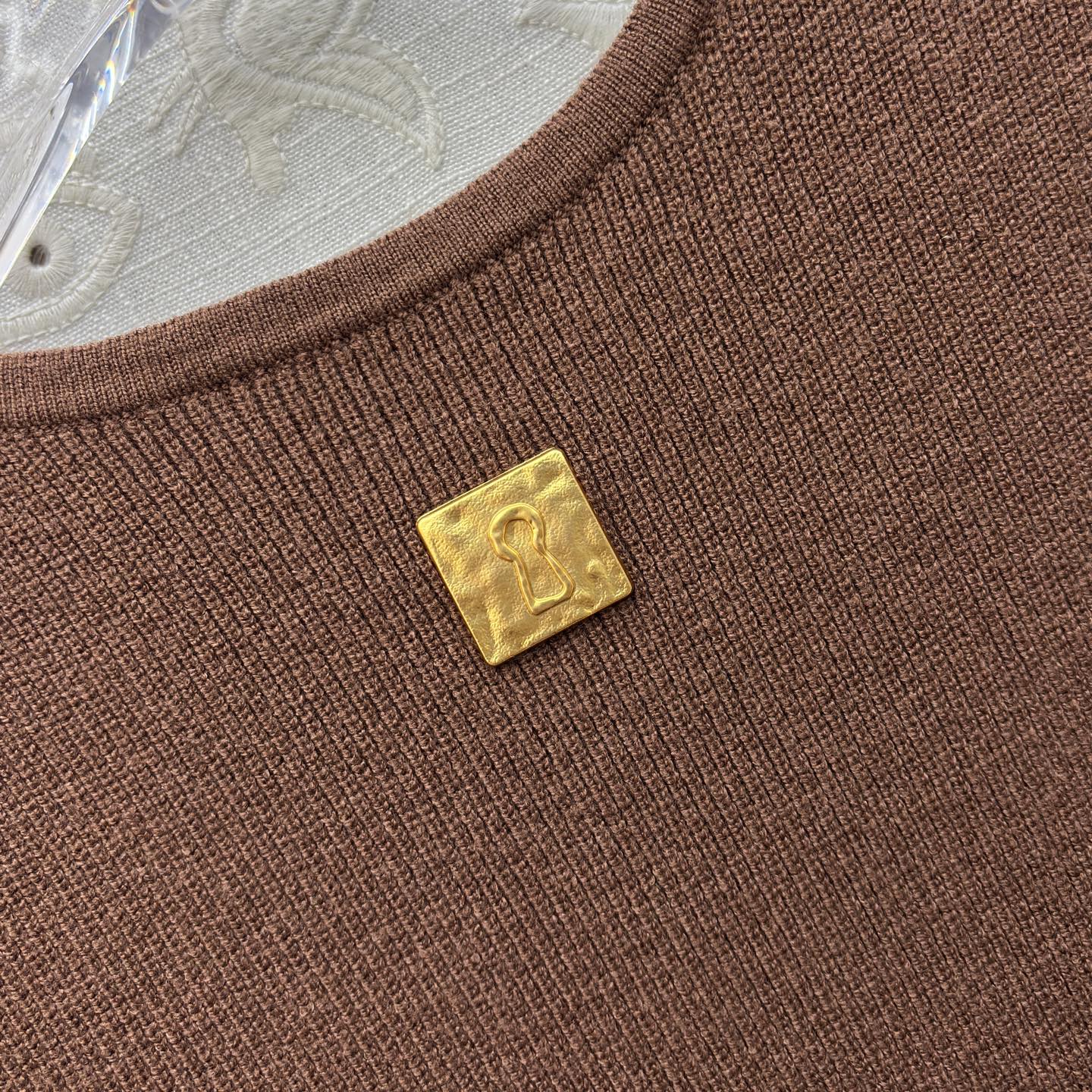 Sch 26早春 异形扣无袖针织连衣裙 以细腻坑条针织面料打造 亲肤又兼具垂坠感 经典圆领搭配纵向异形金