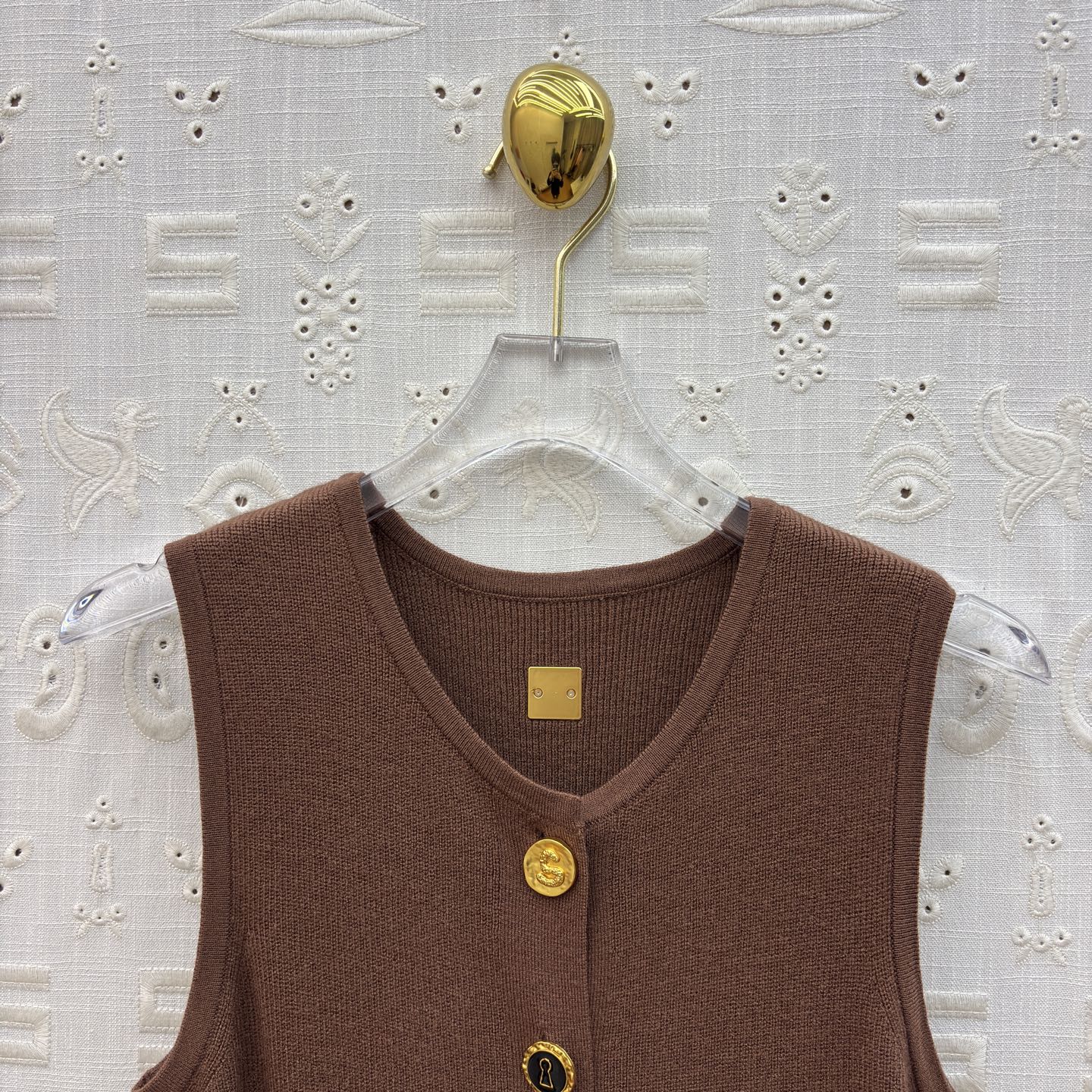 Sch 26早春 异形扣无袖针织连衣裙 以细腻坑条针织面料打造 亲肤又兼具垂坠感 经典圆领搭配纵向异形金