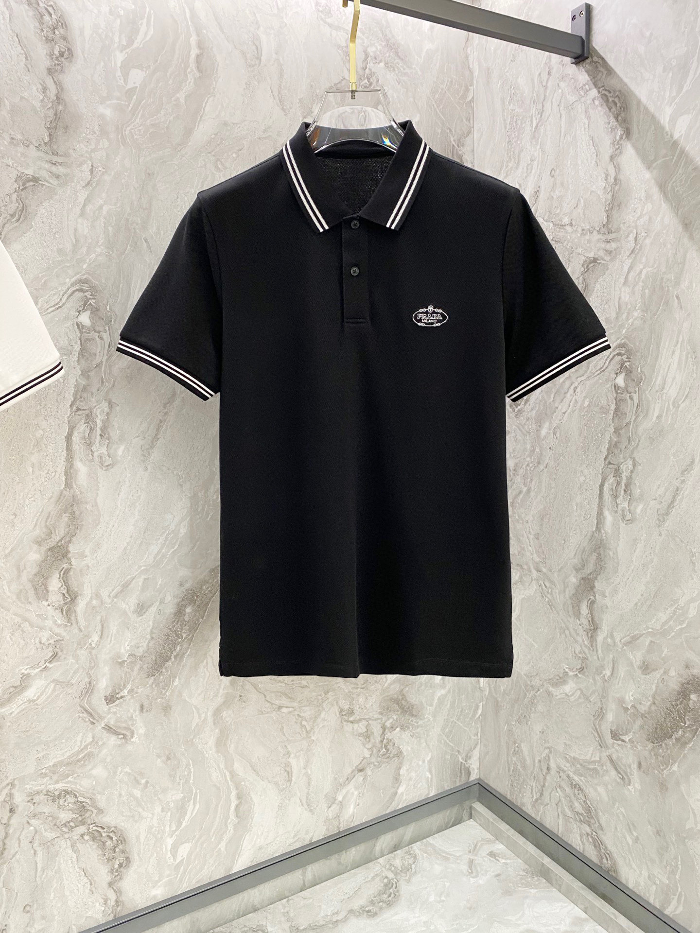 NO:130558,Prada 2025ss summer new brand classic men's lapel Polo shirt!  Classic business men's style, high-end men's style at the ceiling level of business men's style!  Simple, fashionable and elegant, single-wearing inner wear is decent, quality control/detail control takes away, low-key, luxurious and connotative!  Customer-supplied fixed mesh flooring cotton cloth is carefully made, the surface of the fabric is evenly arranged and neatly arranged, with excellent breathability and heat dissipation and sweat resistance, and the comfort level of the upper body is completely better than that of ordinary single-sided sweat cloth tissue!  The brand letter LOGO logo with the classic collar is created with top-level craftsmanship. The LOGO has three-dimensional, clear and full texture, and is an extraordinary product in the classic field whether it is inner wear or single wear!  The exquisite cutting process, the processing of every detail is very standard and delicate, and it is comparable to that of ordinary LOW products on the market. Men must enter the basic versatile Polo shirts!  Color black white Size M-3XL, prada,alexander wang19860909普拉达2025ss夏季新款品牌经典男士翻领Polo衫！经典商务男款,高端男装的天花板级别的商务男款！简约时尚大气不失优雅,单穿内搭体面过人,品质控/细节控的闭眼带走,低调又奢华有内涵！ 客供定织网眼珠地棉布精心制成,面料表面排列均匀整齐的网眼纹理,透气性和散热排汗性极佳,上身舒适程度完全优于普通单面汗布组织！衣领经典的品牌字母LOGO标识,采用顶级工艺打造,LOGO立体清晰饱满,质感非凡的特质,无论是内搭还是单穿都是一款经典领域的产品！精妙绝伦的裁剪工艺,每一个细节处理的非常标准细腻,非市面一般LOW货可以媲美的,男士必入基础百搭款Polo衫推荐！ 颜色黑色 白色 尺码M-3XL,,prada,alexander wang,Men's clothing