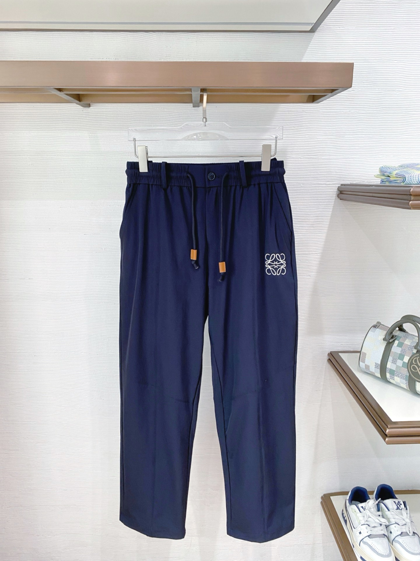 NO:841998,. Luo Yi* summer ice-feel casual pants 'Exquisitely crafted and comfortable in summer' inherit Luo Yi*'s classic aesthetic genes and select high-density ice-feel breathable fabrics. They feel silky and light, with a cool and breathable texture. They can be worn for a long time in summer without being stuffy, sweaty or sticky. One click to unlock the refreshing body feeling all day long.  The neat straight cut cleverly modifies the leg lines, hides the flesh and looks slim while having a relaxed old-money style; the waist drawstring is double designed with buttons, taking into account the casual and neat texture, and adapts to a variety of body shapes.  The iconic Anagram embroidery logo on the trousers is reproduced with exquisite craftsmanship to highlight the high-end taste in a low-key manner; the two classic colors of navy blue and charcoal gray are suitable for various combinations of T-shirts, Polo shirts, shirts, etc. You can easily achieve a light and luxurious atmosphere for daily commuting and leisure travel. They are an indispensable texture and versatile trousers for the summer wardrobe. Color Black Blue Size M-3XL, loewe, shirts, tees, t-shirt,19860909.罗意*夏季冰感休闲裤 「匠心奢造 舒爽入夏」 承袭罗意*经典美学基因,甄选高密冰感透气面料,触感丝滑轻盈,自带凉感透气肌理,夏日久穿不闷汗、不粘身,一键解锁全天候清爽体感. 利落直筒剪裁,巧妙修饰腿型线条,藏肉显瘦同时自带松弛老钱风调性；腰部抽绳搭配纽扣双重设计,兼顾随性休闲与利落质感,适配多元身形. 裤身标志性Anagram刺绣标识,以精湛工艺复刻品牌图腾,低调彰显高阶品味；藏青、炭灰双款经典配色,适配T恤、Polo衫、衬衫等多种穿搭组合,日常通勤、休闲出行皆可轻松拿捏轻奢氛围感,是夏季衣橱不可或缺的质感百搭神裤. 颜色黑色 蓝色 码数M-3XL,,loewe,shirts,tees，t-shirt,,Men's clothing