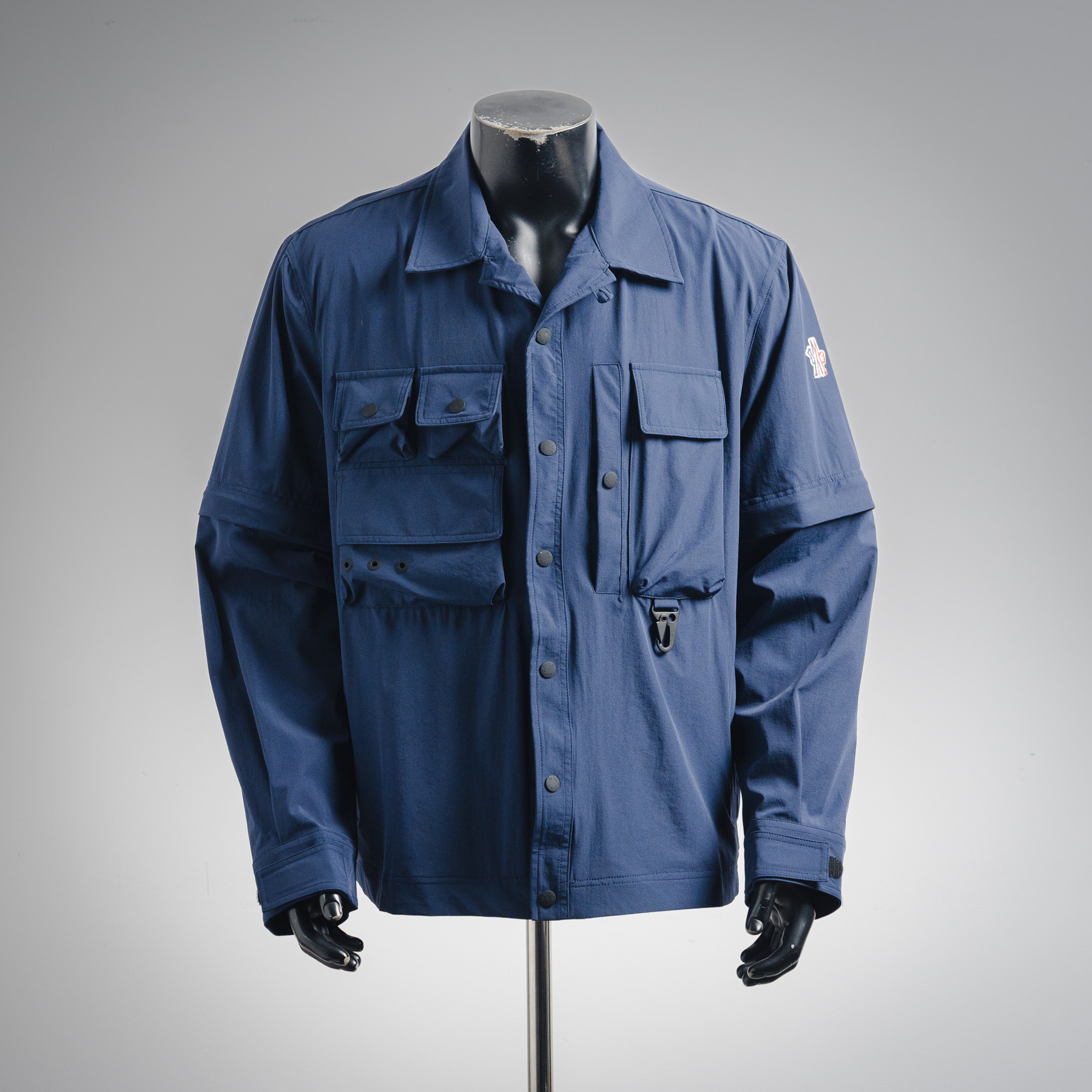 本地自取💰430【一衣两穿】
Moncler Grenoble/蒙口可拆卸多功能户外夹克
原版12,500购入开发，面料采用定制定染双弹丝光府绸 定染柔网春亚纺 质感卓越 舒适贴肤 以深海为灵感的海军蓝 当代绅士的低调宣言 机能口袋系统的精密叙事 功能与美学平衡 标志性Moncler标识标呈现于手袖处 辨识度十足 同色系三角徽标如深海暗流中的印记隐入面料肌理 隐极至显 可拆卸衣袖设计让穿搭多元化 风格随意切换 潇洒自如 尽显尊贵 兼顾户外实用与都市审美的平衡 引领时尚。采用三合一工艺 优先将胶水均匀地涂布在需要复合的基材表面 而后进行烘干固化 再将涂有胶膜的基材与无纺布进行复合 而后冷却固化 再复合过滤无纺布 做工繁琐复杂 耗时耗力。压花复合技术 通过电脑扫描的方式 确保压印大小形状与原版一致 再用特制胶水作为粘合剂结合 再进行固化 达到完全干燥且最佳粘接效果。采用数控激光烧花裁片 基于激光的高能量特性 通过激光发生器精确控制激光束的移动路径 实现精确的裁片形状切割。模版机开袋 预设的模板来指导开袋的位置 形状和大小 精确性确保了开袋效果质量。采用红外线专机钉扣 位置更为精准 牢固结实。
Size:1-2-3-4