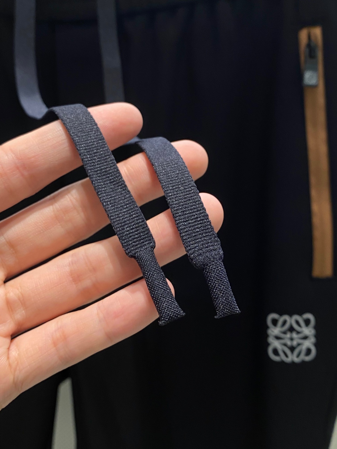 LOE~经典logo刺绣松紧腰散口休闲裤
秋冬新品
精选透气耐磨的优质复合面料，触感柔软亲肤，透气性佳，面料自带轻微垂坠感，不易起皱变形，日常打理更省心。
前经典logo标识刺绣点缀，细腻工整的针脚勾勒出质感，立体感十足，既避免了大面积印花的浮夸，又能通过小细节提升整体造型的辨识度，低调中尽显高贵品味。斜拉口袋大胆的撞色设计是点睛之笔，打破基础款的单调，轻松点亮整体造型，不仅实用能装，更添几分利落动感，日常取物便捷又时髦。
采用利落直筒剪裁，修饰腿型效果出众，能巧妙掩盖腿粗、腿型不直等问题，拉长腿部线条，让身材比例更显优越。无论是搭配简单T恤还是休闲卫衣，便外套，都能瞬间提升吸睛度。松紧腰头不挑身材，穿脱无压力，久穿也不会有束缚感，散口裤型适配多种鞋款，通勤、逛街、约会都能穿，轻松拿捏随性自在的日常风格。

颜色：黑色
规格：M&mdash;XXXL
    P280
L码:腰围78.臀围104.裆长30.裤长99.裤脚口36
XL码：腰围81.臀围108.裆长31.裤长100.裤脚口37