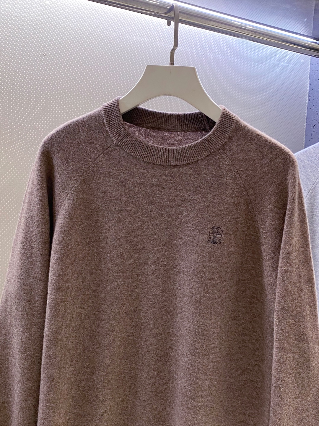 BC~经典logo刺绣叉肩圆领毛衣
秋冬新品
精选高支美丽诺羊毛，把柔软与经典，织进日常质感里&hellip;.触感是肉眼可见的细腻软糯&mdash;&mdash;没有普通羊毛的扎肤感，贴身穿亲肤不刺痒，自带天然的温煦包裹感，既保留羊毛的保暖性，又兼具轻盈透气的特质，秋冬单穿不厚重，叠穿不臃肿。
圆领+叉肩连袖的版型藏着不挑人的包容感！圆领恰到好处不挑脸型更不挑内搭；叉肩袖设计弱化肩线棱角，合身不紧绷的版型，无论是搭任何裤子都能轻松适配。
胸前经典logo刺绣是点睛之笔：没有繁复花样，仅以精致针脚将品牌标识绣于衣身，线条清晰不突兀，既有品牌辨识度又不张扬。整体简约却不简单，把BC一贯的低调优雅藏在羊毛的柔软肌理与经典设计里，日常穿、通勤穿都能透出不经意的质感。

颜色：黑色、驼色、浅灰色
规格：M--XXL
    P310
M码：连肩袖74、胸围110、衣长67
L码：连肩袖75、胸围114、衣长68