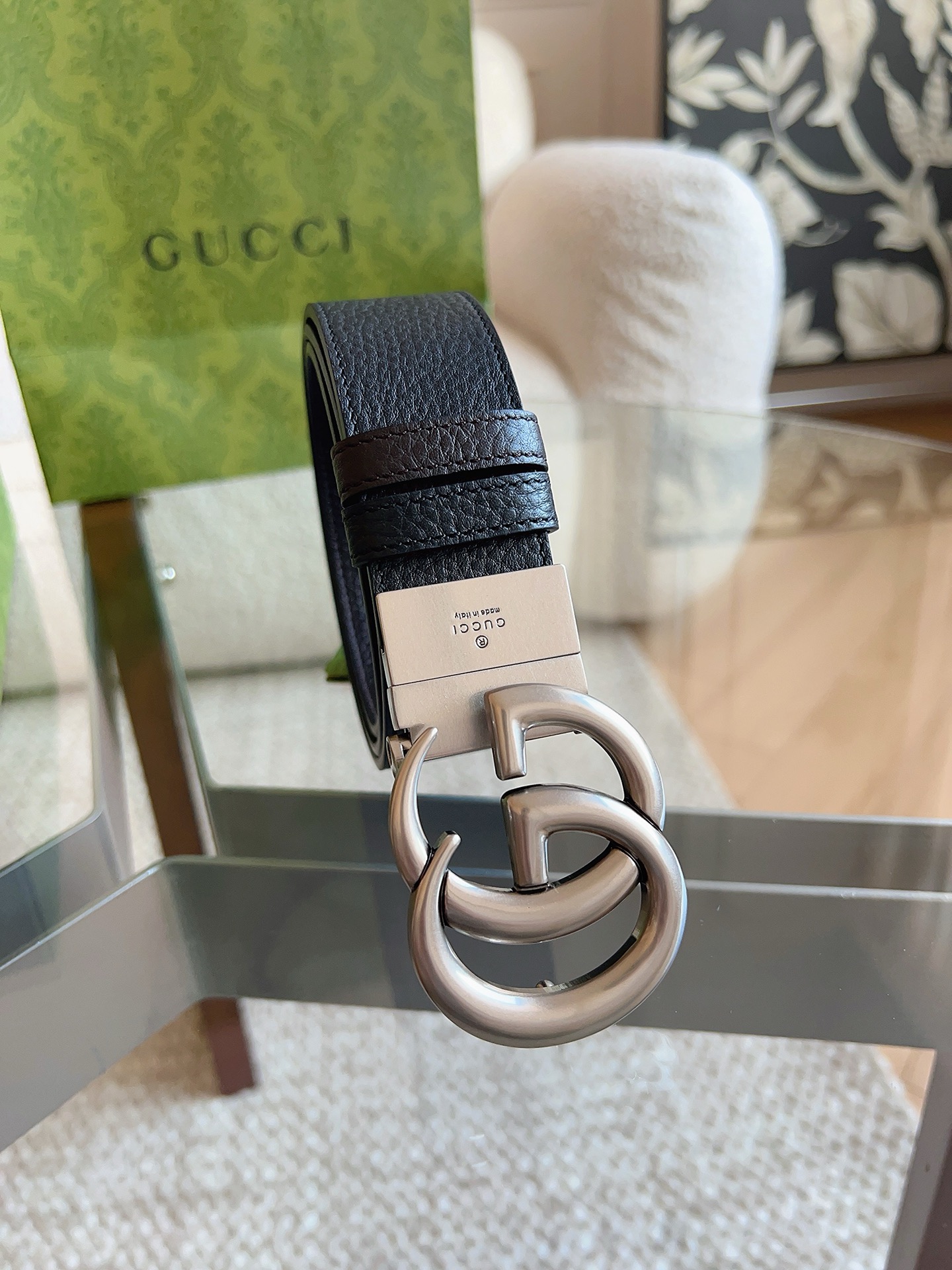 GUCCI 这款双面皮革腰带采用荔枝纹皮革材质，饰以经典双G搭扣，该配件灵感源自品牌辉煌的70年代典藏设