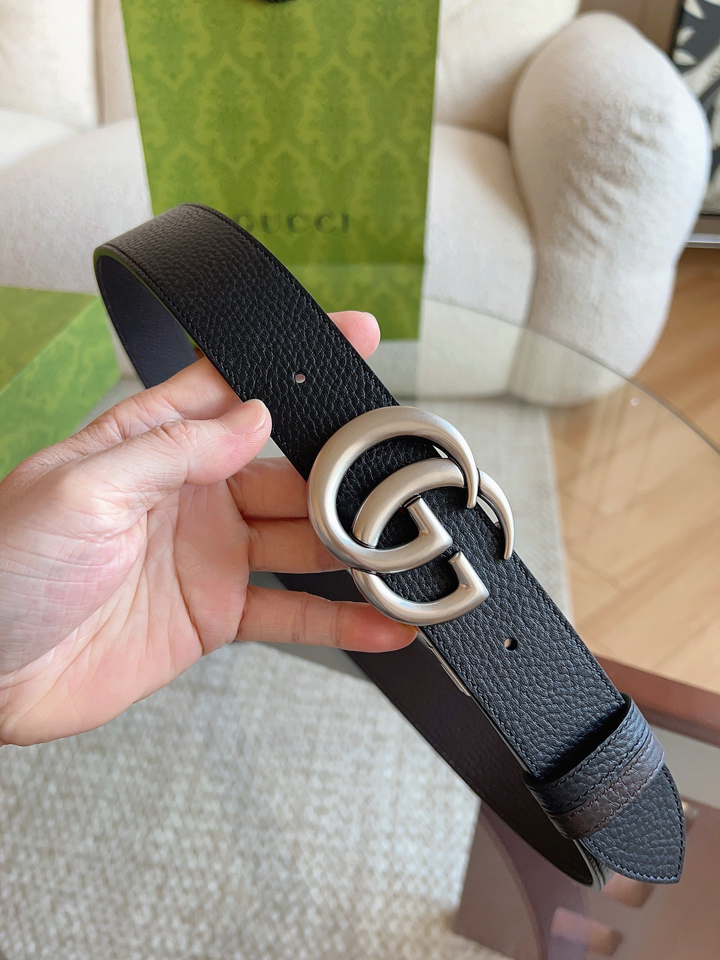 GUCCI 这款双面皮革腰带采用荔枝纹皮革材质，饰以经典双G搭扣，该配件灵感源自品牌辉煌的70年代典藏设