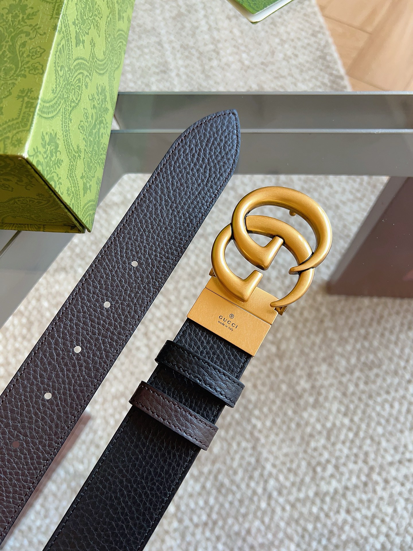 GUCCI 这款双面皮革腰带采用荔枝纹皮革材质，饰以经典双G搭扣，该配件灵感源自品牌辉煌的70年代典藏设