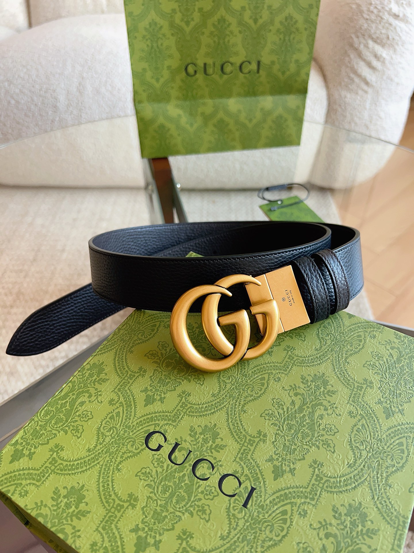 GUCCI 这款双面皮革腰带采用荔枝纹皮革材质，饰以经典双G搭扣，该配件灵感源自品牌辉煌的70年代典藏设