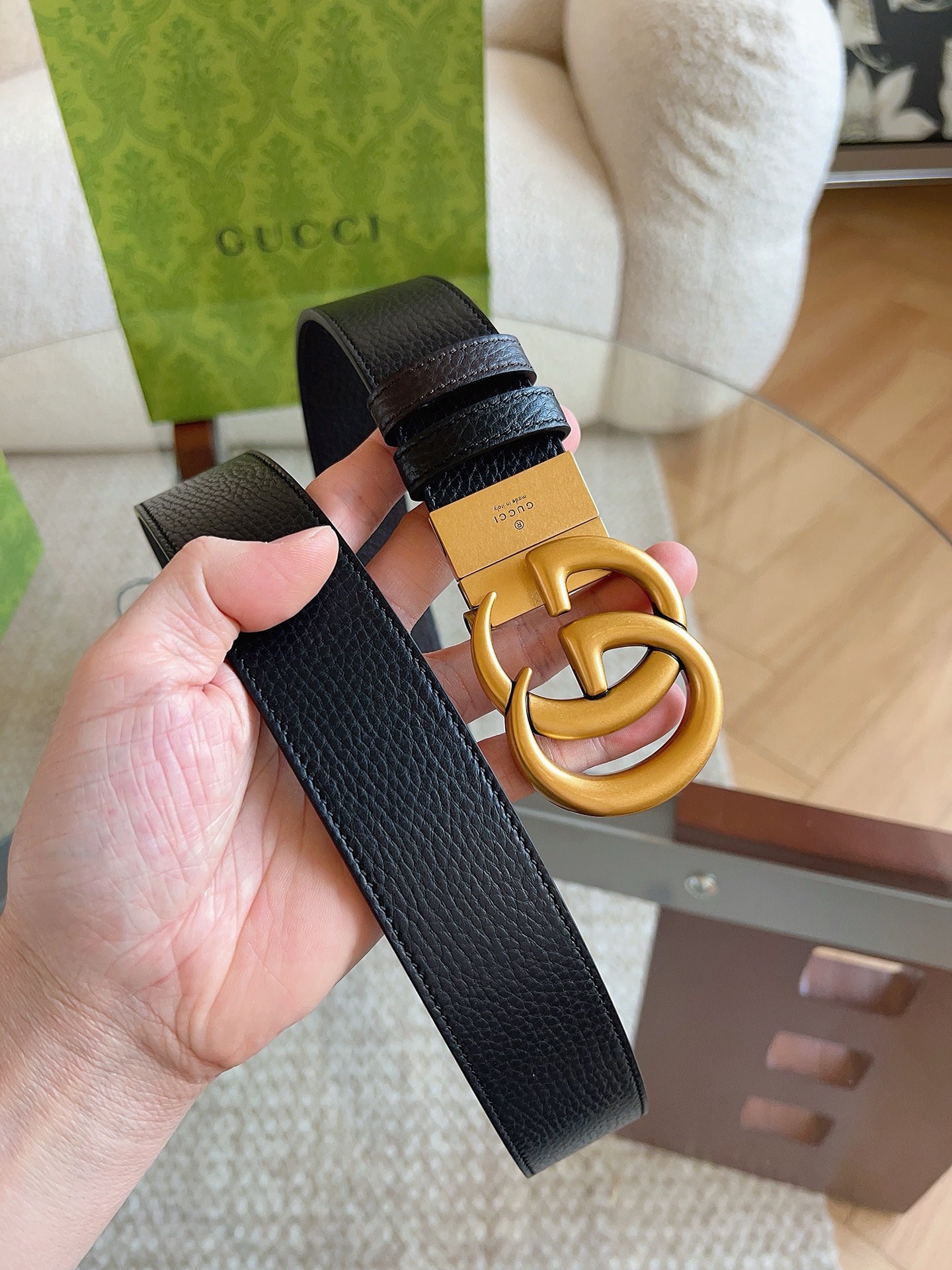 GUCCI 这款双面皮革腰带采用荔枝纹皮革材质，饰以经典双G搭扣，该配件灵感源自品牌辉煌的70年代典藏设