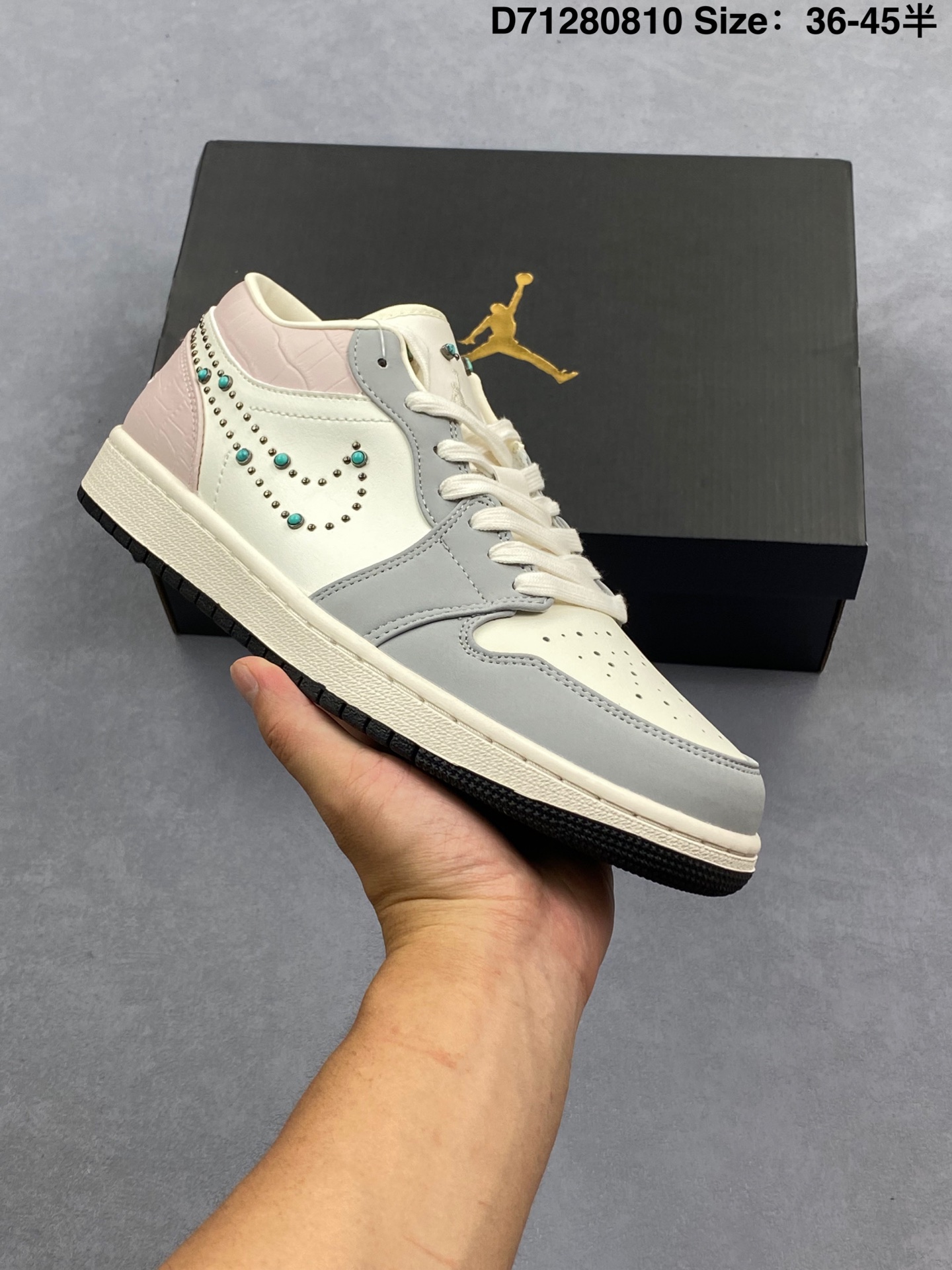 Air Jordan 1 Low 低帮 绿松石钩子 AJ1 乔丹1代 aj1 乔1 低邦 灰白粉 乔丹篮球鞋系列 鞋身整体采用柔和的米白色皮革,搭配灰色框架覆盖层,鞋领及后跟粉色鳄鱼压纹质感,散发出低调而清新的气息;创新之处在于鞋侧Swooshh Logo标志上采用绿松石和铆钉制成的串珠,为鞋款增添了奢华感;此外,鞋舌上镶嵌着绿松石般的铆钉,仿佛有些许摇滚的味道,Jumpman Logo以奶白色刺绣呈现,鞋领内衬与后跟经典的Wings Loggo标志则采用了同色调处理,浅粉色的加入使鞋款尽显优雅格调;最后以奶油色的中底搭配黑色橡胶外底完善整体设计收尾. 货号:IH7319-001 编码:D71280810 半