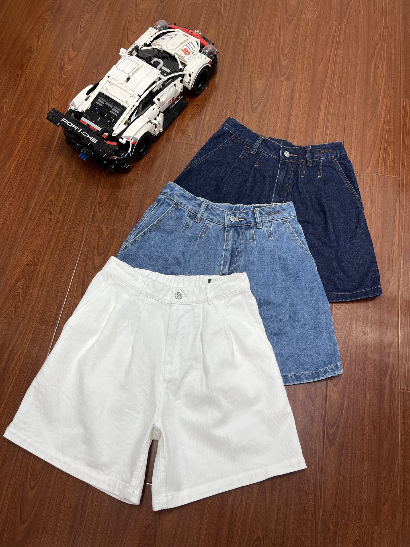 P120    顶尖现货    Hazzys哈吉斯牛仔短裤女2025夏季新款复古时尚裤子舒适潮流休闲裤！！
PHIZ牛仔短裤。
可以从夏天穿到秋天的一条牛仔短裤~
韩国知名时尚品牌，主打英伦复古风，注重剪裁和面料品质，适合追求优雅休闲风格的人群。
延续了复古潮流的设计，面料采用棉质混纺，透气柔软，提升舒适度。
金属纽扣、腰间品牌刺绣logo、立体口袋等细节增强设计感。
高腰+后腰松紧+阔腿设计
这个组合360°凸显腰细腿细
宽腰型、梨形、苹果型身材的女生穿
也可以毫无压力驾驭~
特别凸显腰细胯窄腿细
定制定染高级复古白 水洗蓝  藏青蓝 三色 百搭不挑人
夏天搭配各种颜色上衣都可
衣柜里几乎没有它不能搭配的
颜色：复古白  水洗蓝   藏青蓝
尺码：160–170
160码：腰围67臀围98裤长43建议100斤以下
165码：腰围71臀围102裤长44建议100-120斤左右
170码：腰围75臀围106裤长45建议120-140斤左右