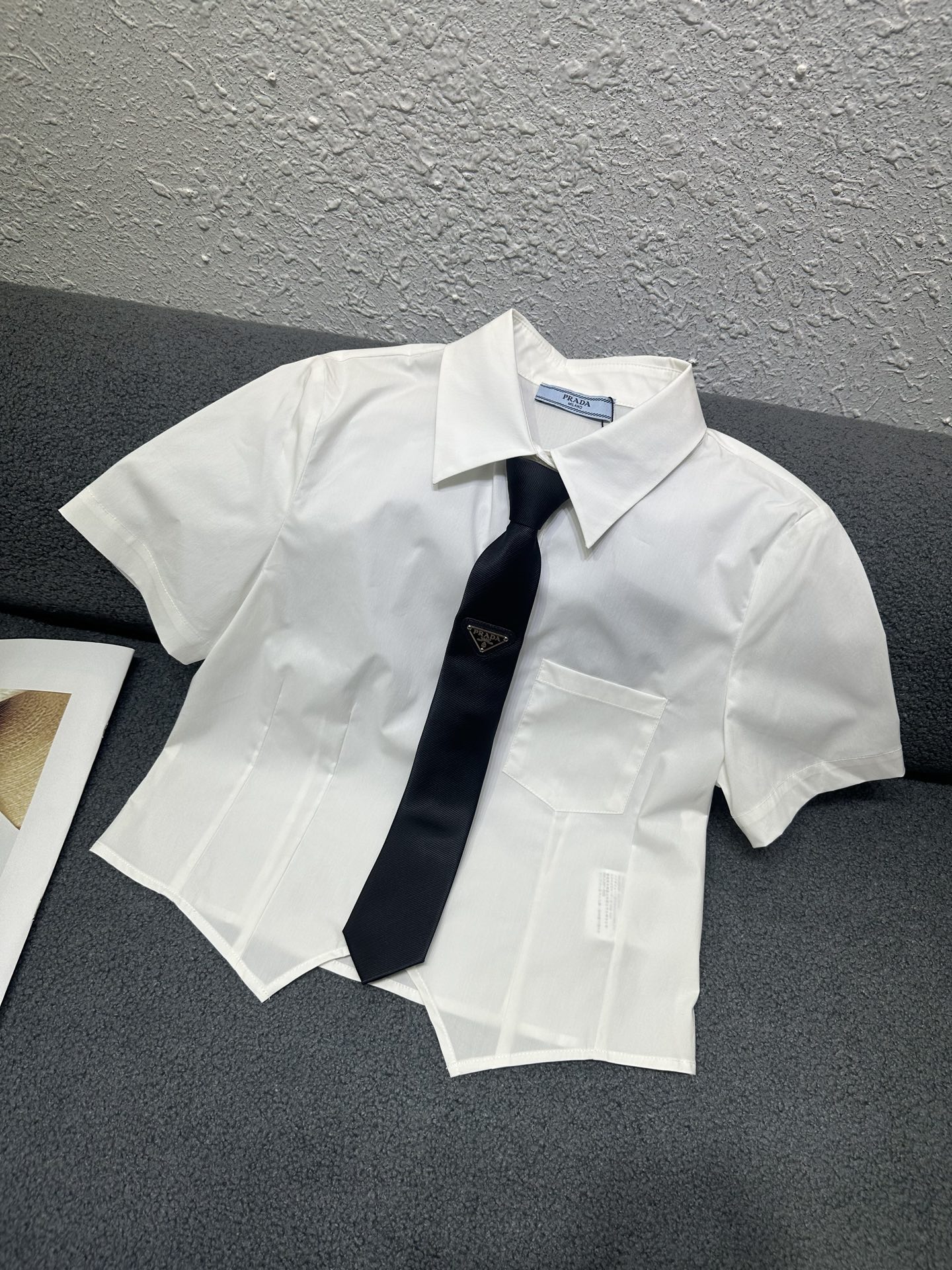 NO:790741,Prada*2026 new summer style lapel short-sleeved shirt. It is exquisite and elegant with a customized tie. The hem is irregularly cut to increase the layering. The version is fashionable and slim. Monochrome SML P,,prada,T-shirt,ties,19860909Prada*2026夏季新款翻领短袖衬衣 搭配定制领带精致优雅 下摆做不规则剪裁增加层次感 版型洋气修身 单色SML P,,prada,T-shirt,ties,,Women's clothing