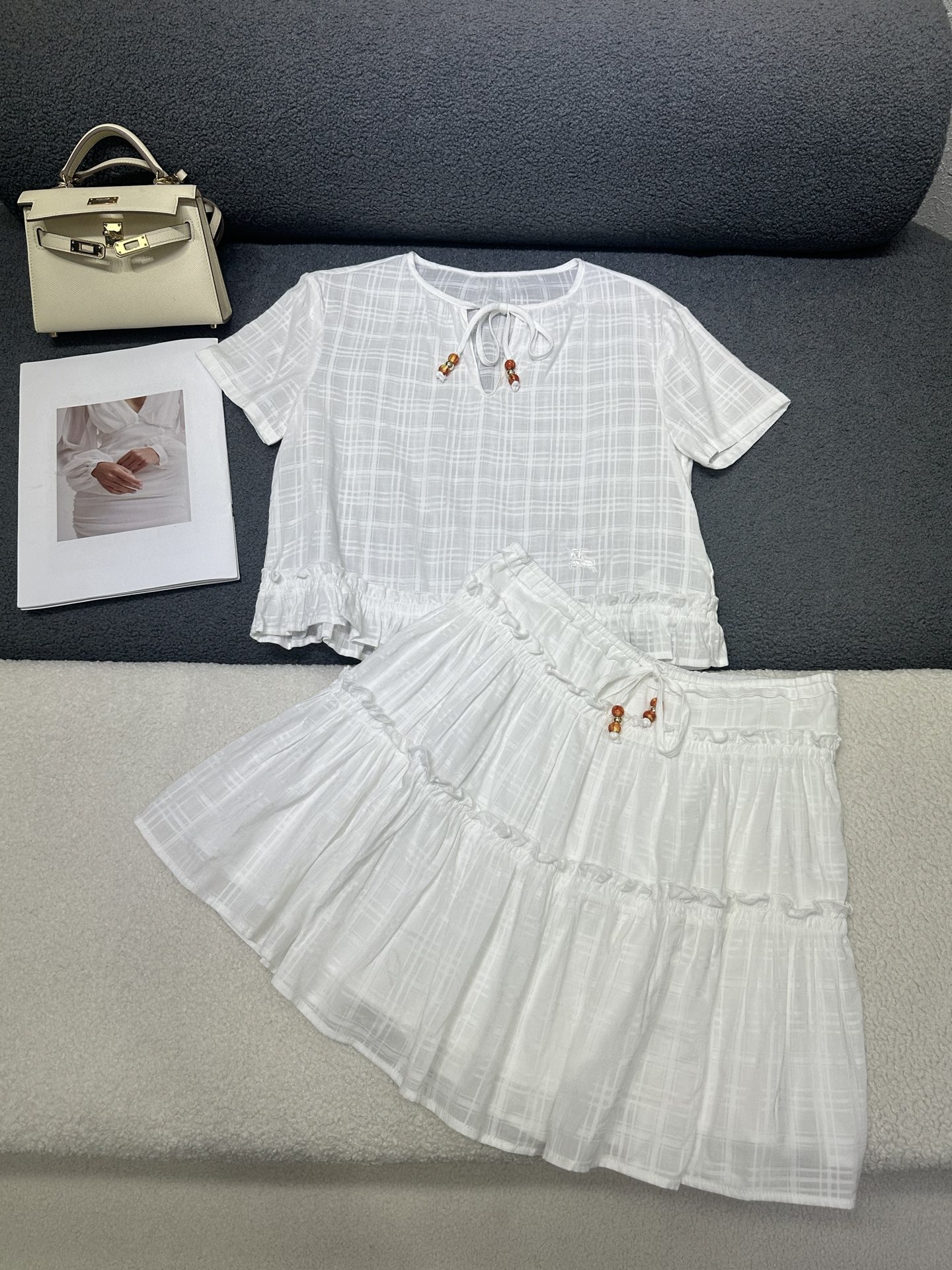 NO:865356,Burberry*2026 new summer suit. Short-sleeved shirt and short skirt. The whole body is made of slightly see-through textured cotton fabric with a gentle feeling. The neckline/waist tie with exquisite pendant shows the temperament. The splicing ruffle design adds a sense of layering. Fresh and age-reducing with holiday style. Monochrome SML,,burberry,skirts,T-shirt,19860909Burberry*2026夏季新款套装 短袖衬衣短款半裙 通体微透肌理感棉质面料自带温柔感 领口/腰部系带搭配精致吊坠超显气质 拼接荷叶边设计增加层次感 清新减龄带有度假风 单色SML,,burberry,skirts,T-shirt,,Women's clothing