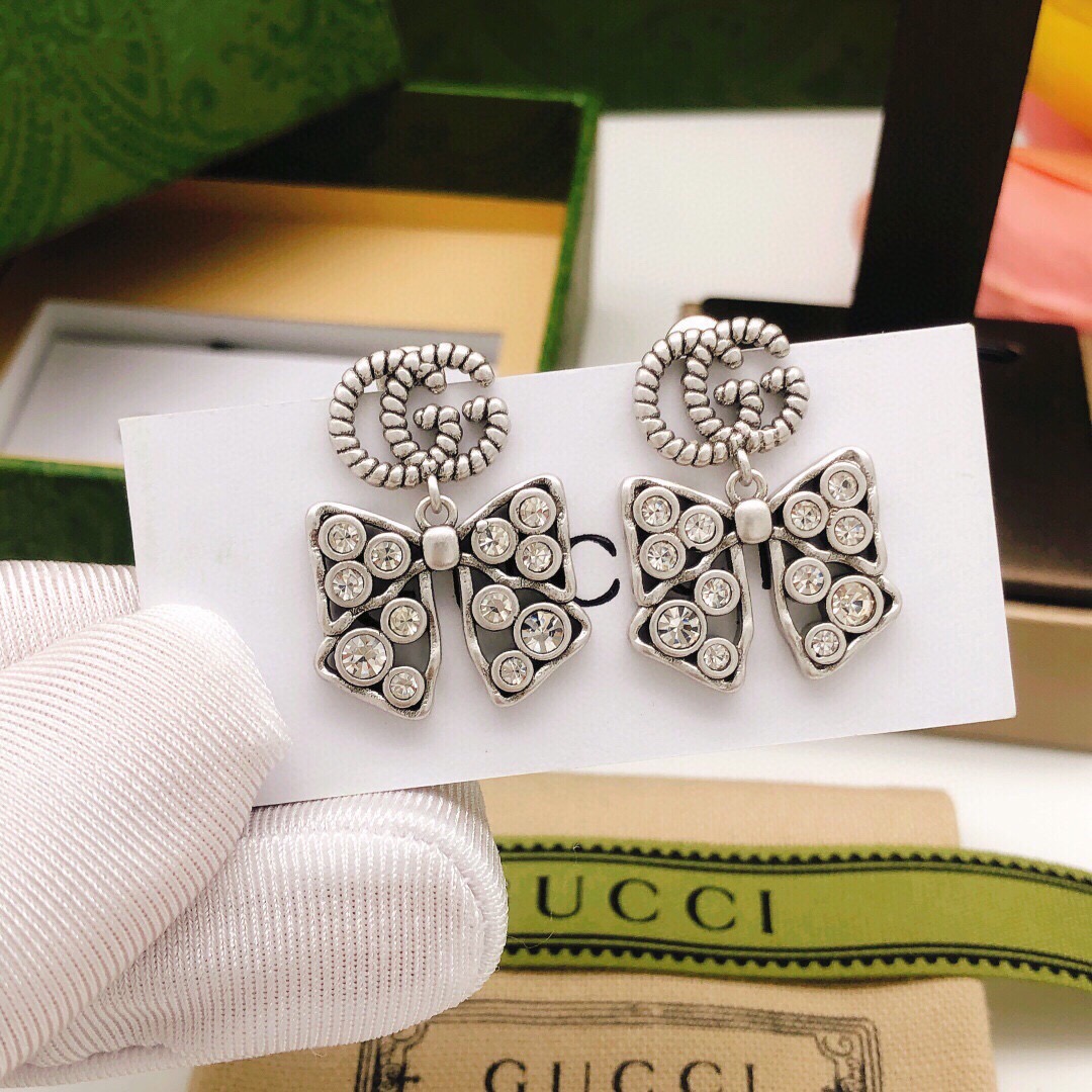 Número GED0124 dorado Número GED0161 plateado Pendientes de lazo Gucci 🎀 Diseño clásico de doble G entrelaza…