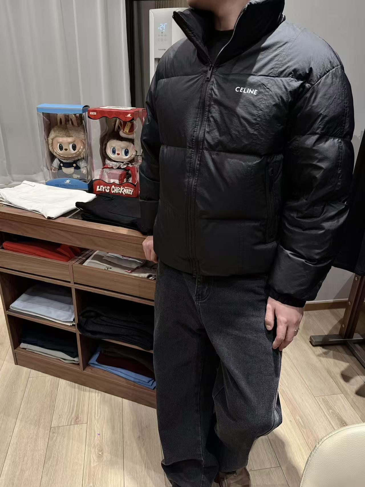 NO:712147,CEL** Frosted Black High-Filled Down Jacket This frosted black down jacket combines French minimalist aesthetics with high-end thermal performance, becoming a luxurious addition to your autumn and winter wardrobe.  The body is made of nylon matte fabric. The matte black tone has a low-key luxury atmosphere. The fabric is wind-resistant, wear-resistant and light and drapey. It has no stiffness like ordinary down fabrics when touched, showing the brand's exquisite texture. The interior is filled with 90 white duck down and is designed with a high filling capacity, which has excellent bulk and warmth. The three-dimensional plaid quilting process firmly locks the down to avoid running down and clumping, and can maintain comfort and warmth even in low temperature environments.  The classic stand-up collar silhouette is optimized for loose tailoring, and the minimalist white CELI** letter logo print on the chest contrasts sharply with the matte black fabric, becoming the visual focus without being ostentatious; the metallic zipper accessories are smooth and durable, and the cuffs are elasticated.  The design is effective in windproofing and temperature locking, and the hidden zippered side pockets combine practicality with the simplicity of the overall shape. The multi-lingual wash labels clearly indicate the fabric ingredients and care instructions, and the details confirm the authentic craftsmanship. It is a must-have item for autumn and winter that pursues quality and style.  Men's model, black, M-3XL. Flat measurement error 1-3CM error M code: shoulder width 56 bust 116 dress length 64 sleeves 58 L code: shoulder width 57 bust 130 dress length 66 sleeves 59  3XL size: shoulder width 60, bust 142, length 72, sleeves 62. Size recommendation: Choose M size if you are under 135 catties; choose L size if you are 135-150 catties;19860909CEL**磨砂黑高充绒羽绒服 这款磨砂黑羽绒服,将法式极简美学与高阶保暖性能融为一体,成为秋冬衣橱的奢华质感担当. 采用锦纶磨砂面料打造衣身,哑光质感的黑色调自带低调奢华氛围,面料抗风耐磨且轻盈垂顺,触碰时无普通羽绒面料的生硬感,尽显品牌精工质感.内里填充90白鸭绒高充绒量设计,蓬松度与保暖性双优,立体格纹绗缝工艺牢牢锁住羽绒,避免跑绒结块,即便在低温环境也能保持舒适暖意. 经典立领廓形经宽松剪裁优化,胸前极简的白色CELI**字母标识印花,与磨砂黑面料形成鲜明对比,成为视觉焦点却不张扬；金属质感的拉链配件顺滑耐用,袖口松紧收口设计有效防风锁温,侧边隐形拉链口袋兼顾实用性与整体造型的简洁度.多语种洗水标清晰标注面料成分与护理说明,细节处印证正品级工艺,是追求品质与格调的秋冬必备单品. 男款,黑色 ,M-3XL. 平铺测量1-3CM误差 M码:肩宽56胸围116衣长64袖子58 L码:肩宽57胸围130衣长66袖子59 XL码:肩宽58胸围134衣长68袖子60 XXL码:肩宽59胸围138衣长70袖子61 3XL码:肩宽60胸围142衣长72袖子62 尺码推荐 135斤以下选择M码;135-150斤选择L码； 150-170斤选择XL码；170-185斤选择XXL码； 185-200斤选择3XL码,,celine,down jacket,,Men's clothing