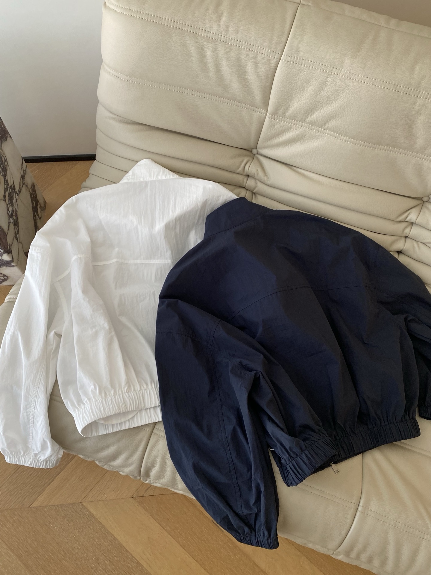26SS 早春新款立领刺绣防晒夹克采用利落短款立领廓形，纯净白/藏青双调自带清爽滤镜，胸口与衣身小马抽象