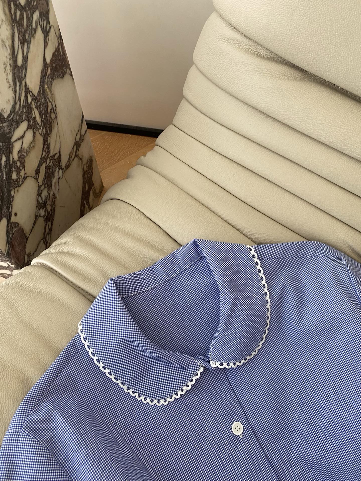 26SS 春夏新款娃娃领蕾丝边格纹衬衫采用抗皱肌理格纹面料打造宽松直筒版型，清爽蓝调自带干净减龄滤镜，娃