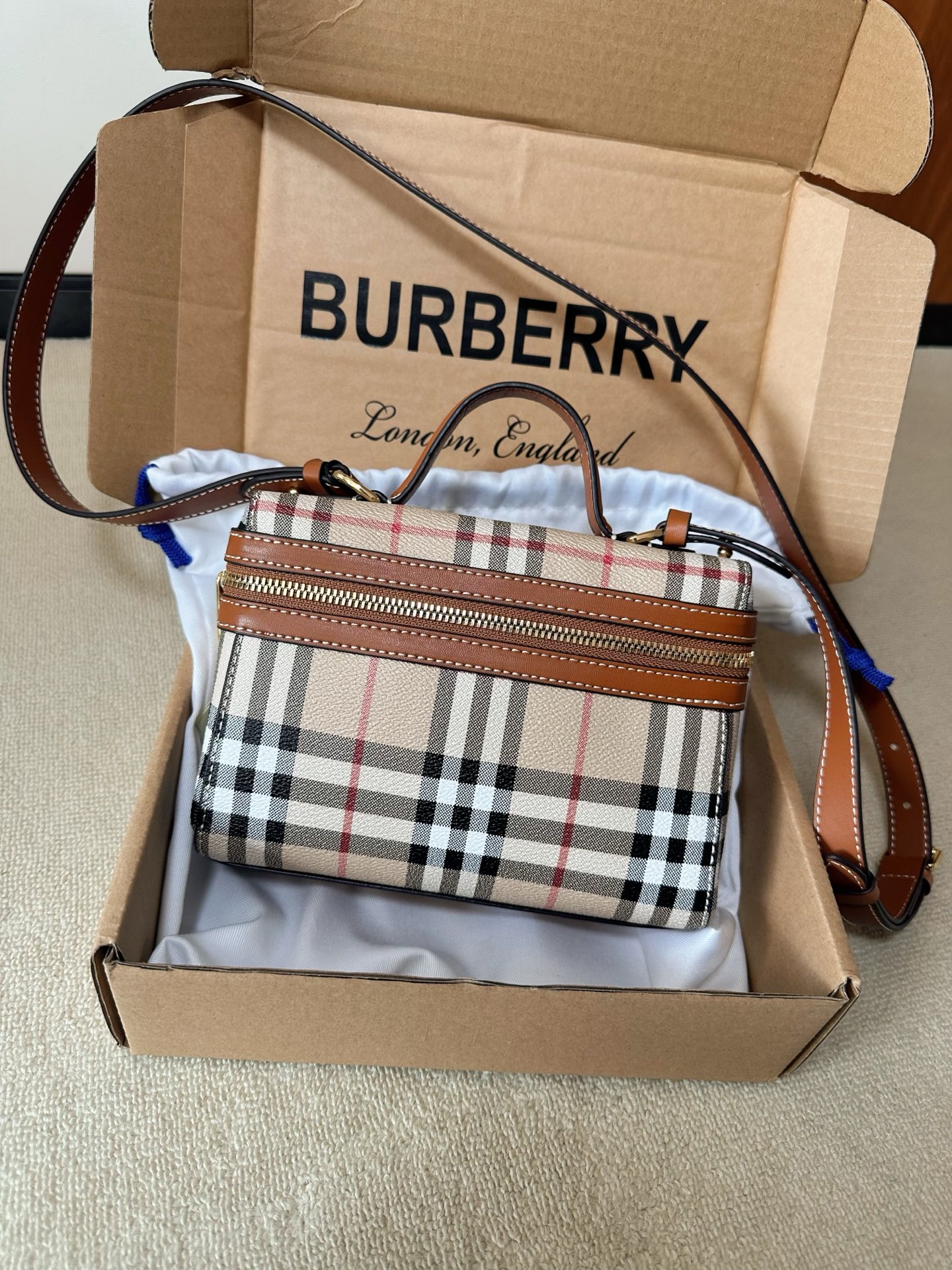 NO:902489,Put a century of British elegance into a gift box. The iconic plaid is paired with a retro Vanity bag. Giving it to yourself is a reward, giving it to your lover is a thoughtful gift, making this classic texture easy to get.,,19860909把英伦百年的优雅装进礼盒. 标志性格纹搭配复古Vanity包型, 送自己是犒赏,送爱人是心意, 让这份经典质感轻松入手.,,,Women's clothing
