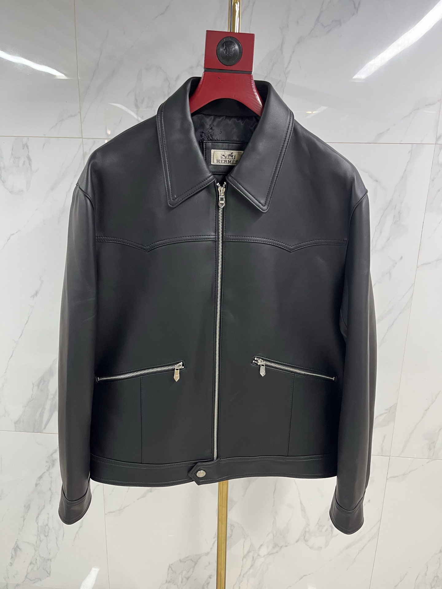 NO:868100,Hermes men's sheepskin lapel leather jacket  As warm and moist as ever, when the cold wind of the city comes, a Hermès sheepskin lapel leather jacket is the armor for you to be calm and leisurely. Select top-grade sheepskin, which feels as delicate and flexible as silk, surpassing ordinary sheepskin, light and fit the body, but rich in texture  It hides extraordinary muscles and bones. The natural leather surface flows over time, depositing a deep and warm unique luster, telling a story that only belongs to you. Every inch is dedicated to extraordinary skills by Hermès craftsmen. The sharp lapels outline the sharp outlines and are precisely cut.  The tailoring gives the shoulder line impeccable grace. The button opening and closing are meticulously detailed. The lining is lined with silky fabric, which continues the luxurious feel in a low-key manner. This is not only a barrier against the cold wind, but also a silent expression of the contemporary gentleman's character.  Declaration. From the sharpness and connotation of business meetings to the freedom and ease of traveling in the city, it always has a warm texture to accompany you in different scenes. Hermès leather jackets are carved with time and style, and one piece is eternal - the longer the time, the better they understand you.  Code number 48——58 Coding: ---,Hermes-clothing,hermes,leather jacket,sheepskin,19860909爱马仕男士绵羊皮翻领皮衣 温润如初,当城市寒流裹挟而至,一件爱马仕绵羊皮翻领皮衣,便是你从容不迫的铠甲.甄选顶级绵羊皮,触感如丝般细腻柔韧,超越普通羊皮,轻盈贴合身姿,却蕴藏不凡筋骨.天然皮面随时间流转,沉淀出深邃温润的独有光泽,诉说只属于你的故事.每一寸皆由爱马仕工匠倾注非凡技艺,利落翻领勾勒棱角分明的轮廓,精准剪裁赋予肩线无可挑剔的英挺.纽扣开合间,是严丝合缝的细节执着.内里衬以丝滑织物,于低调中延续奢华体感.这不仅是抵御寒风的屏障,更是当代绅士品格的无声宣言.从商务会晤的锋芒内蕴,到都市穿梭的洒脱自如,它始终以温润质感,伴你游刃于不同场景.爱马仕皮衣,以时光雕琢风度,一件即永恒——时间越久,越懂你. 码数48———58编码: ---,爱马仕-服装,hermes,leather jacket,sheepskin,,Women's clothing