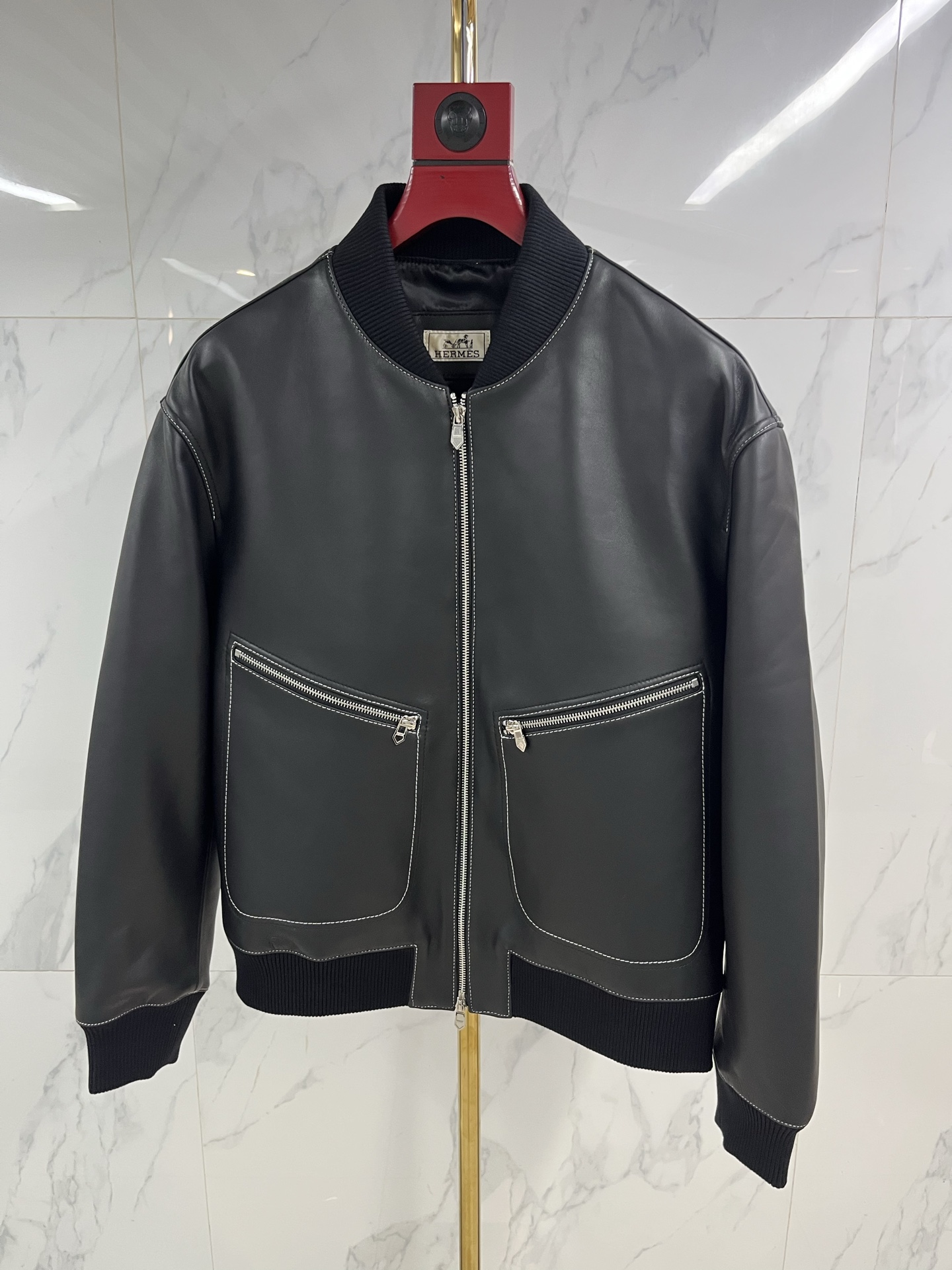NO:870870,Hermes men's sheepskin lapel leather jacket  As warm and moist as ever, when the cold wind of the city comes, a Hermès sheepskin lapel leather jacket is the armor for you to be calm and leisurely. Select top-grade sheepskin, which feels as delicate and flexible as silk, surpassing ordinary sheepskin, light and fit the body, but rich in texture  It hides extraordinary muscles and bones. The natural leather surface flows over time, depositing a deep and warm unique luster, telling a story that only belongs to you. Every inch is dedicated to extraordinary skills by Hermès craftsmen. The sharp lapels outline the sharp outlines and are precisely cut.  The tailoring gives the shoulder line impeccable grace. The button opening and closing are meticulously detailed. The lining is lined with silky fabric, which continues the luxurious feel in a low-key manner. This is not only a barrier against the cold wind, but also a silent expression of the contemporary gentleman's character.  Declaration. From the sharpness and connotation of business meetings to the freedom and ease of traveling in the city, it always has a warm texture to accompany you in different scenes. Hermès leather jackets are carved with time and style, and one piece is eternal - the longer the time, the better they understand you.  Code number 48——58 coding: Hermes-clothing,hermes,leather jacket,sheepskin,19860909爱马仕男士绵羊皮翻领皮衣 温润如初,当城市寒流裹挟而至,一件爱马仕绵羊皮翻领皮衣,便是你从容不迫的铠甲.甄选顶级绵羊皮,触感如丝般细腻柔韧,超越普通羊皮,轻盈贴合身姿,却蕴藏不凡筋骨.天然皮面随时间流转,沉淀出深邃温润的独有光泽,诉说只属于你的故事.每一寸皆由爱马仕工匠倾注非凡技艺,利落翻领勾勒棱角分明的轮廓,精准剪裁赋予肩线无可挑剔的英挺.纽扣开合间,是严丝合缝的细节执着.内里衬以丝滑织物,于低调中延续奢华体感.这不仅是抵御寒风的屏障,更是当代绅士品格的无声宣言.从商务会晤的锋芒内蕴,到都市穿梭的洒脱自如,它始终以温润质感,伴你游刃于不同场景.爱马仕皮衣,以时光雕琢风度,一件即永恒——时间越久,越懂你. 码数48———58编码:,爱马仕-服装,hermes,leather jacket,sheepskin,,Women's clothing