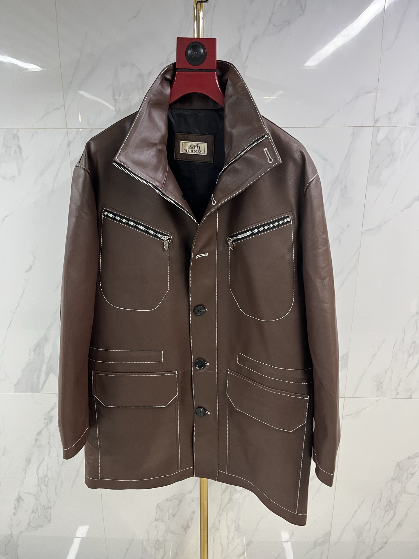 NO:871048,Hermès Men's Sheepskin Lapel Mid-Length Leather Jacket When the cold wind in the city comes, a big-brother style Hermès sheepskin lapel leather jacket is the armor for you to be calm and leisurely. The top-grade sheepskin is selected and feels as delicate and flexible as silk, surpassing ordinary sheep.  Leather is light and fits the body, but contains extraordinary muscles and bones. The natural leather surface flows over time, depositing a deep and warm unique luster, telling a story that only belongs to you. Every inch is made by Hermès craftsmen with extraordinary skills, and the sharp lapels outline the sharp edges.  The silhouette and precise tailoring give the shoulder line impeccable grace. The button opening and closing are meticulously detailed. The lining is lined with silky fabric, which continues the luxurious feel in a low-key manner. This is not only a barrier against the cold wind, but also the character of a contemporary gentleman.  A silent declaration. From the sharpness and connotation of business meetings to the freedom and ease of traveling in the city, it always has a warm texture and accompanies you in different scenes. Hermès leather jackets use time to carve elegance, and one piece is eternal - the longer the time, the better they understand you.  Code number 48——58 coding: Hermes-clothing,hermes,leather jacket,sheepskin,19860909爱马仕男士绵羊皮翻领中长款皮衣当城市寒流裹挟而至,大哥风范一件爱马仕绵羊皮翻领皮衣,便是你从容不迫的铠甲.甄选顶级绵羊皮,触感如丝般细腻柔韧,超越普通羊皮,轻盈贴合身姿,却蕴藏不凡筋骨.天然皮面随时间流转,沉淀出深邃温润的独有光泽,诉说只属于你的故事.每一寸皆由爱马仕工匠倾注非凡技艺,利落翻领勾勒棱角分明的轮廓,精准剪裁赋予肩线无可挑剔的英挺.纽扣开合间,是严丝合缝的细节执着.内里衬以丝滑织物,于低调中延续奢华体感.这不仅是抵御寒风的屏障,更是当代绅士品格的无声宣言.从商务会晤的锋芒内蕴,到都市穿梭的洒脱自如,它始终以温润质感,伴你游刃于不同场景.爱马仕皮衣,以时光雕琢风度,一件即永恒——时间越久,越懂你. 码数48———58编码:,爱马仕-服装,hermes,leather jacket,sheepskin,,Women's clothing