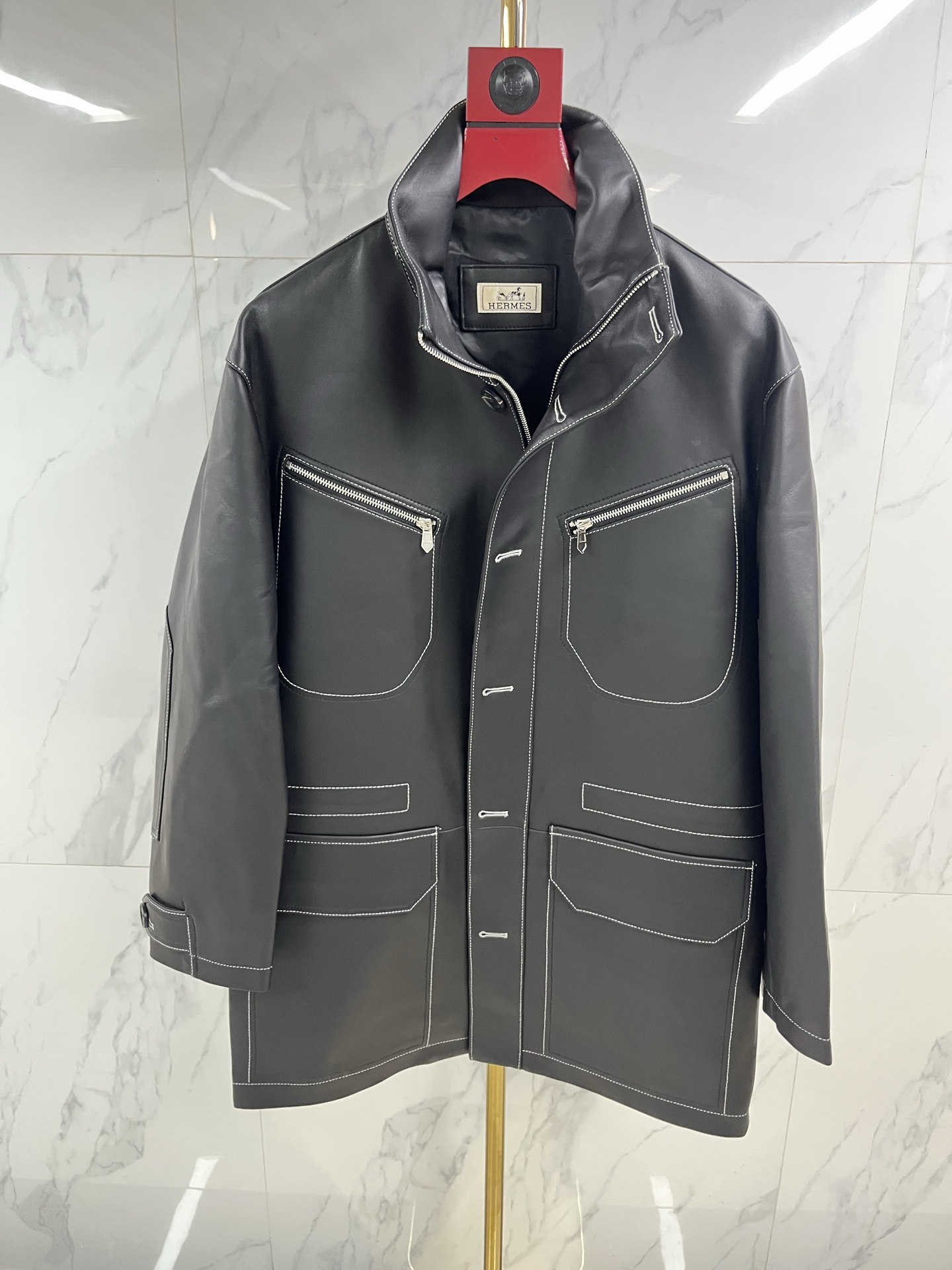 NO:871185,Hermès Men's Sheepskin Lapel Mid-Length Leather Jacket When the cold wind in the city comes, a big-brother style Hermès sheepskin lapel leather jacket is the armor for you to be calm and leisurely. The top-grade sheepskin is selected and feels as delicate and flexible as silk, surpassing ordinary sheep.  Leather is light and fits the body, but contains extraordinary muscles and bones. The natural leather surface flows over time, depositing a deep and warm unique luster, telling a story that only belongs to you. Every inch is made by Hermès craftsmen with extraordinary skills, and the sharp lapels outline the sharp edges.  The silhouette and precise tailoring give the shoulder line impeccable grace. The button opening and closing are meticulously detailed. The lining is lined with silky fabric, which continues the luxurious feel in a low-key manner. This is not only a barrier against the cold wind, but also the character of a contemporary gentleman.  A silent declaration. From the sharpness and connotation of business meetings to the freedom and ease of traveling in the city, it always has a warm texture and accompanies you in different scenes. Hermès leather jackets use time to carve elegance, and one piece is eternal - the longer the time, the better they understand you.  Code number 48——58 coding: Hermes-clothing,hermes,leather jacket,sheepskin,19860909爱马仕男士绵羊皮翻领中长款皮衣当城市寒流裹挟而至,大哥风范一件爱马仕绵羊皮翻领皮衣,便是你从容不迫的铠甲.甄选顶级绵羊皮,触感如丝般细腻柔韧,超越普通羊皮,轻盈贴合身姿,却蕴藏不凡筋骨.天然皮面随时间流转,沉淀出深邃温润的独有光泽,诉说只属于你的故事.每一寸皆由爱马仕工匠倾注非凡技艺,利落翻领勾勒棱角分明的轮廓,精准剪裁赋予肩线无可挑剔的英挺.纽扣开合间,是严丝合缝的细节执着.内里衬以丝滑织物,于低调中延续奢华体感.这不仅是抵御寒风的屏障,更是当代绅士品格的无声宣言.从商务会晤的锋芒内蕴,到都市穿梭的洒脱自如,它始终以温润质感,伴你游刃于不同场景.爱马仕皮衣,以时光雕琢风度,一件即永恒——时间越久,越懂你. 码数48———58编码:,爱马仕-服装,hermes,leather jacket,sheepskin,,Women's clothing