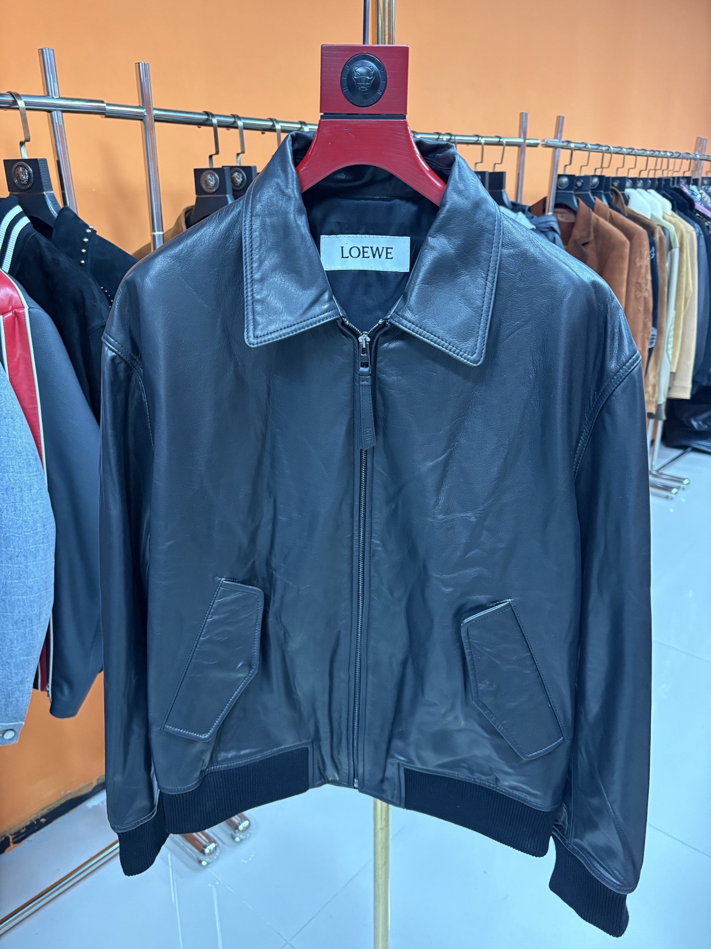 NO:870650,LOEWE  Loewe's new leather jacket for autumn and winter, a new model of men's fashion. At the forefront of fashion, Loewe has always been synonymous with excellent quality and innovative design. In the autumn and winter of this year, Loewe once again used extraordinary creativity to bring a unique sheepskin jacket to men, showing the unique charm of a modern gentleman. This jacket is made of Australian sheepskin and has a bright color.  Deep and full of charm, it is like wearing the mysterious tranquility of the autumn forest on your body. The sheepskin texture is delicate and soft, and has excellent durability. As time goes by, it will increasingly show its unique luster and texture. The lapel slip-shoulder version is the finishing touch of this jacket. The lapel design is simple and neat, adding a bit of sophistication and ease; the slip-shoulder  The tailoring breaks the traditional constraints, weakens the shoulder lines, and creates a casual and relaxed feeling, which can be easily controlled regardless of body shape, perfectly interpreting the fashion attitude of modern men. The threaded design of the hem is not only practical, but also highlights the quality in the details. It is effectively windproof and warm, ensuring that it can remain warm and comfortable in cold weather; at the same time,  The elasticity of the thread makes wearing more comfortable and unrestricted movement. The Loewe brand LOGO patched under the back collar is a low-key and luxurious status symbol. Exquisite craftsmanship and delicate materials complement each other, inadvertently revealing the brand's profound heritage and high-end quality. Only those who know the industry can understand the taste and style at a glance.  . Code number 48——58 code, Loewe-clothing, loewe, loewe, jackets & coats, leather jacket, sheepskin,19860909LOEWE 罗意威秋冬新款皮衣,男士时尚新典范在时尚的前沿舞台,罗意威一直是卓越品质与创新设计的代名词.年秋冬,罗意威再次以非凡创意,为男士们带来了一款别具一格的羊皮夹克,尽显现代绅士的独特魅力.这款夹克精选澳洲羊皮,色泽深沉而富有韵味,宛如将秋日森林的神秘静谧穿在身上.羊皮质感细腻柔软,兼具卓越的耐用性,随着时间的推移,会愈发彰显出独有的光泽与质感.翻领溜肩版型是这件夹克的点睛之笔,翻领设计简洁利落,增添了几分干练与洒脱；溜肩剪裁打破传统束缚,弱化肩部线条,营造出随性自在的松弛感,无论何种身形都能轻松驾驭,完美诠释现代男士的时尚态度.下摆的螺纹设计不仅实用,更在细节处彰显品质.它有效防风保暖,确保在寒冷天气中也能保持温暖舒适；同时,螺纹的弹性让穿着更加自在,活动不受限制.后衣领下方的罗意威品牌LOGO贴皮,是低调而奢华的身份象征.精致的工艺与细腻的材质相得益彰,不经意间流露出品牌的深厚底蕴与高端品质,只有懂行的人才能一眼洞悉其中的品味与格调 . 码数48———58编码,罗意威-服装,loewe,loewe,jackets & coats,leather jacket,sheepskin,,Women's clothing