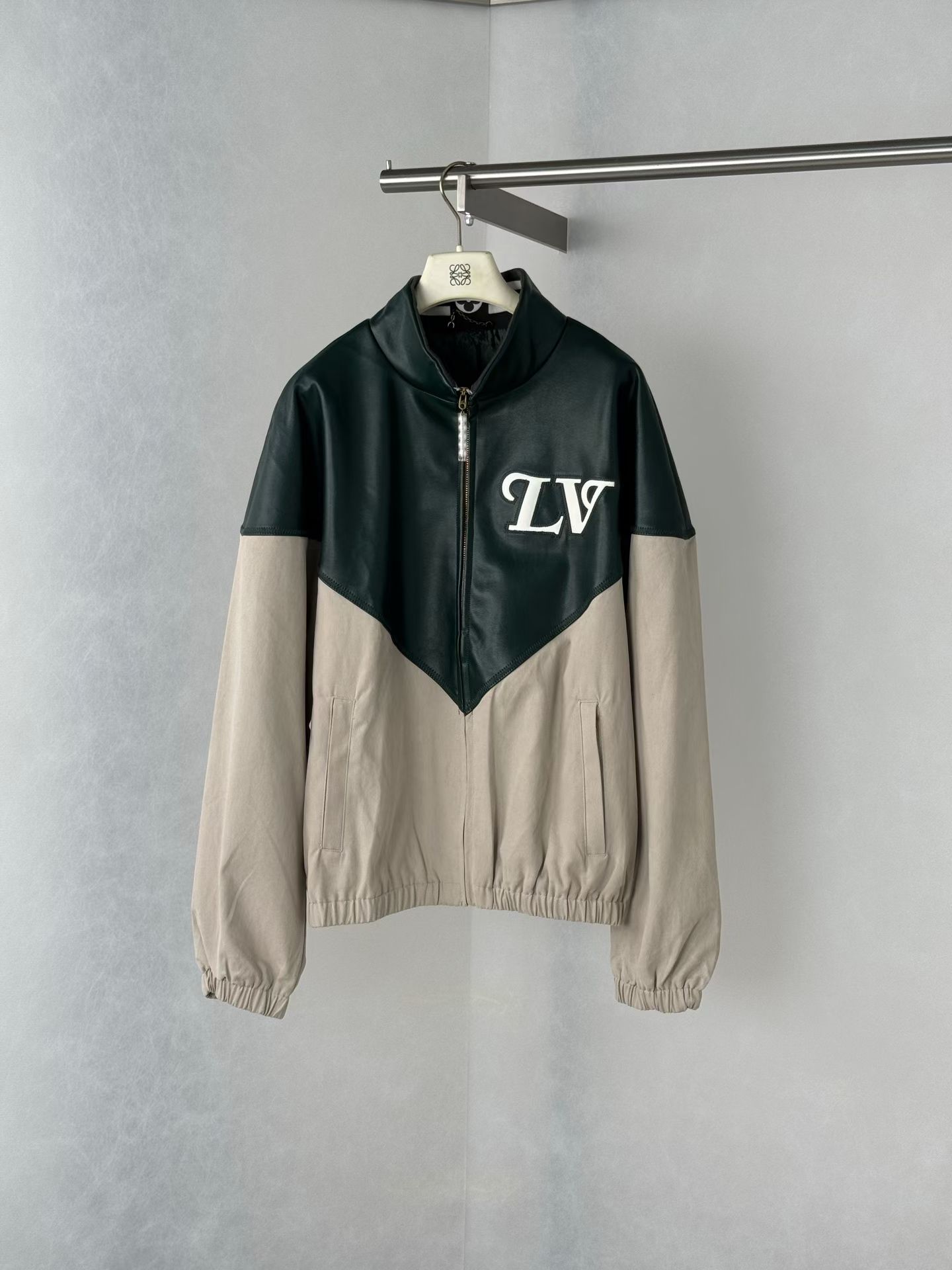 NO:931348,Hong Kong Louis SS26  The capsule series is a gray-green contrasting leather spliced jacket. The upper body is made of dark green leather with outstanding texture. It has a delicate luster and a high-end feel, quietly integrating luxury genes; the lower body is matched with light gray cotton fabric, which is soft and skin-friendly, injecting a casual and casual atmosphere into the overall look. The collision of leather and cotton materials  , it is not only a double visual enjoyment, but also a diverse tactile experience, which perfectly balances toughness and softness. The eye-catching logo highlights the brand genes. The eye-catching white 'LV' logo on the chest is presented in retro fonts. It is not only a clear demonstration of the brand identity, but also adds a sense of retro trend to the overall design, allowing you to  Easily become the focus of fashion among the crowd, always exuding the brand's unique luxury charm. The details are genuine, and the craftsmanship casts quality. The stand-up collar design is neat and stylish, and the pearl decoration at the zipper is exquisite and unique, which embellishes the overall look with an elegant charm; the cuffs and hem are tightened to enhance the comfort of wearing.  It also makes the silhouette more neat and crisp. Every detail embodies Louis Vuitton's exquisite craftsmanship, demonstrating the brand's ultimate pursuit of quality. Whether it is daily outings or fashion parties, this patchwork jacket allows you to easily control various styles and become a fashionista with both retro style and avant-garde attitude.  Code number 48-58,Louis Vuitton-clothing,louis vuitton,louis vuitton,jackets & coats,jackets & coats,19860909香港路易 SS26 胶囊系列灰绿撞色皮质拼接夹克外套,上半身甄选质感出众的深绿色皮革,光泽细腻且富有高级感,将奢华基因悄然融入；下半身搭配浅灰色棉质面料,柔软亲肤,为整体造型注入随性休闲气息.皮革与棉的材质碰撞,不仅是视觉的双重享受,更是触觉的多元体验,完美平衡了硬朗与柔和.标识醒目,彰显品牌基因,胸前醒目的白色“LV”标识,以复古字体呈现,既是品牌身份的鲜明彰显,又为整体设计增添了复古潮流感,让你在人群中轻松成为时尚焦点,时刻散发品牌独有的奢华魅力.细节见真章,工艺铸品质.立领设计利落有型,拉链处的珍珠装饰精致别致,为整体造型点缀出优雅韵味；袖口与下摆的收束设计,既提升了穿着的舒适度,又让版型更显利落挺括.每一处细节都凝聚着路易威登的精湛工艺,彰显着品牌对品质的极致追求.无论是日常出街还是时尚派对,这款拼接夹克都能让你轻松驾驭各种风格,成为兼具复古格调与先锋态度的时尚达人. 码数48—58编码,路易威登-服装,louis vuitton,louis vuitton,jackets & coats,jackets & coats,,Women's clothing