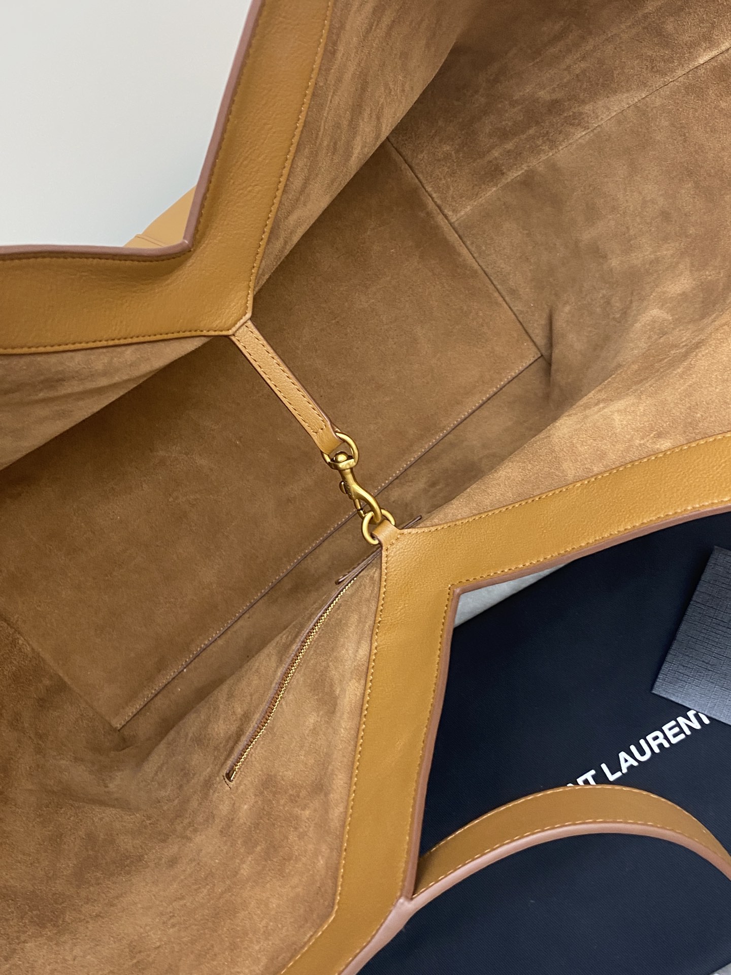 p1350。  棕平纹/古金
🌈Y家新款精细粒面皮革托特包！同色系绒面革全衬里设计~饰以自品牌历史典藏汲取灵感的精美Y字母标志_购物包轻盈容量大！设有一个内部拉链袋和钩扣开合，绒面皮衬里 古铜色金属饰件钩扣开合内部一个拉链袋、极简线条构成的Y 简约而不简单！包包型随意又率性！牛皮材质做得非常轻软又好打理👍
型号：817602【原厂皮】
尺寸: 底长𝟑𝟗×高𝟑𝟒×袋口长𝟔𝟎-宽𝟐𝟐𝙘𝙢
(注：此款尺寸没配包装)