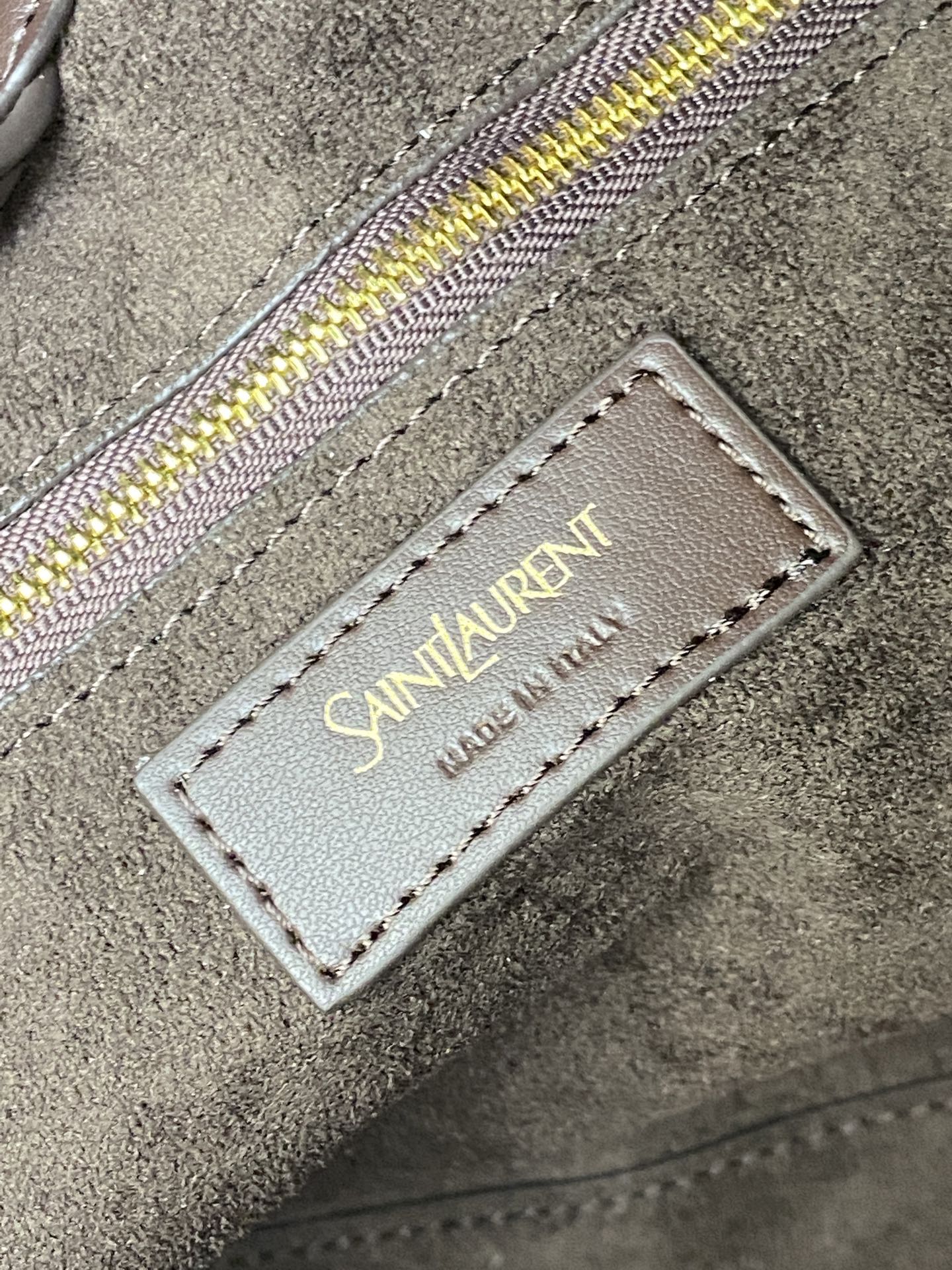 p1350。  深咖啡平纹/古金
🌈Y家新款精细粒面皮革托特包！同色系绒面革全衬里设计~饰以自品牌历史典藏汲取灵感的精美Y字母标志_购物包轻盈容量大！设有一个内部拉链袋和钩扣开合，绒面皮衬里 古铜色金属饰件钩扣开合内部一个拉链袋、极简线条构成的Y 简约而不简单！包包型随意又率性！牛皮材质做得非常轻软又好打理👍
型号：817602【原厂皮】
尺寸: 底长𝟑𝟗×高𝟑𝟒×袋口长𝟔𝟎-宽𝟐𝟐𝙘𝙢
(注：此款尺寸没配包装)