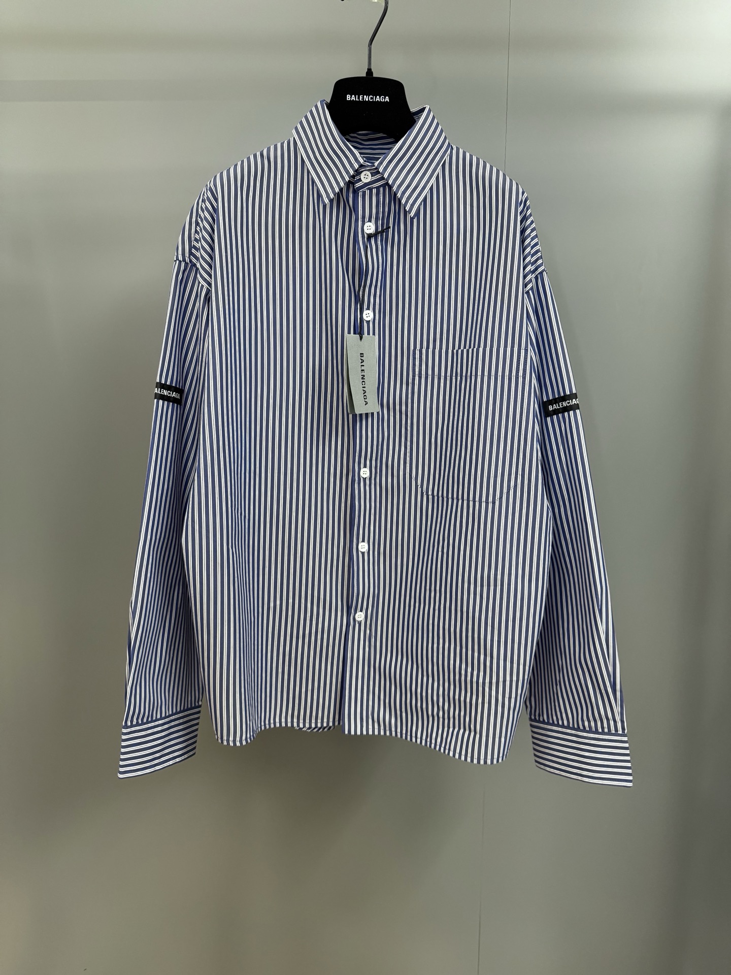 NO:779363,Balenciaga 26SS spring and summer new long-sleeved lapel shirt, customized blue and white small plaid cotton fabric, letter patch pockets on both sides of the arms, curved sleeve hem, placket lettering button design OS version, Balenciaga-clothing, balenciaga,19860909巴黎世家26SS春夏新款长袖翻领衬衣,定制蓝白小格纹棉质面料,手臂双侧字母贴布口袋,弧形衣袖下摆,门襟刻字纽扣设计 OS版本,巴黎世家-服装,balenciaga,,Women's clothing